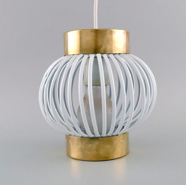 Two designer pendants in brass and white plastic. 1960s / 70s.
Measures: 18 x 18 cm.
In excellent condition.