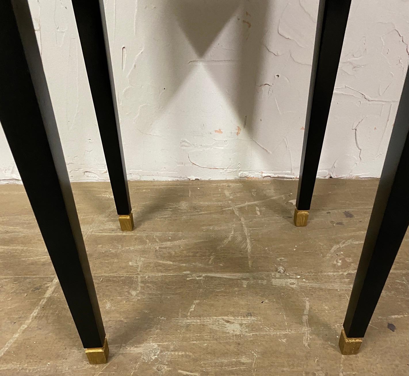 Two stylish small black lacquered Donghia Mardrid side tables with tapered legs and square brass caps. Great small tables to set beside a chair or sofa to set a drink down on. The tables can be moved easily to suit many needs. Tables can be sold