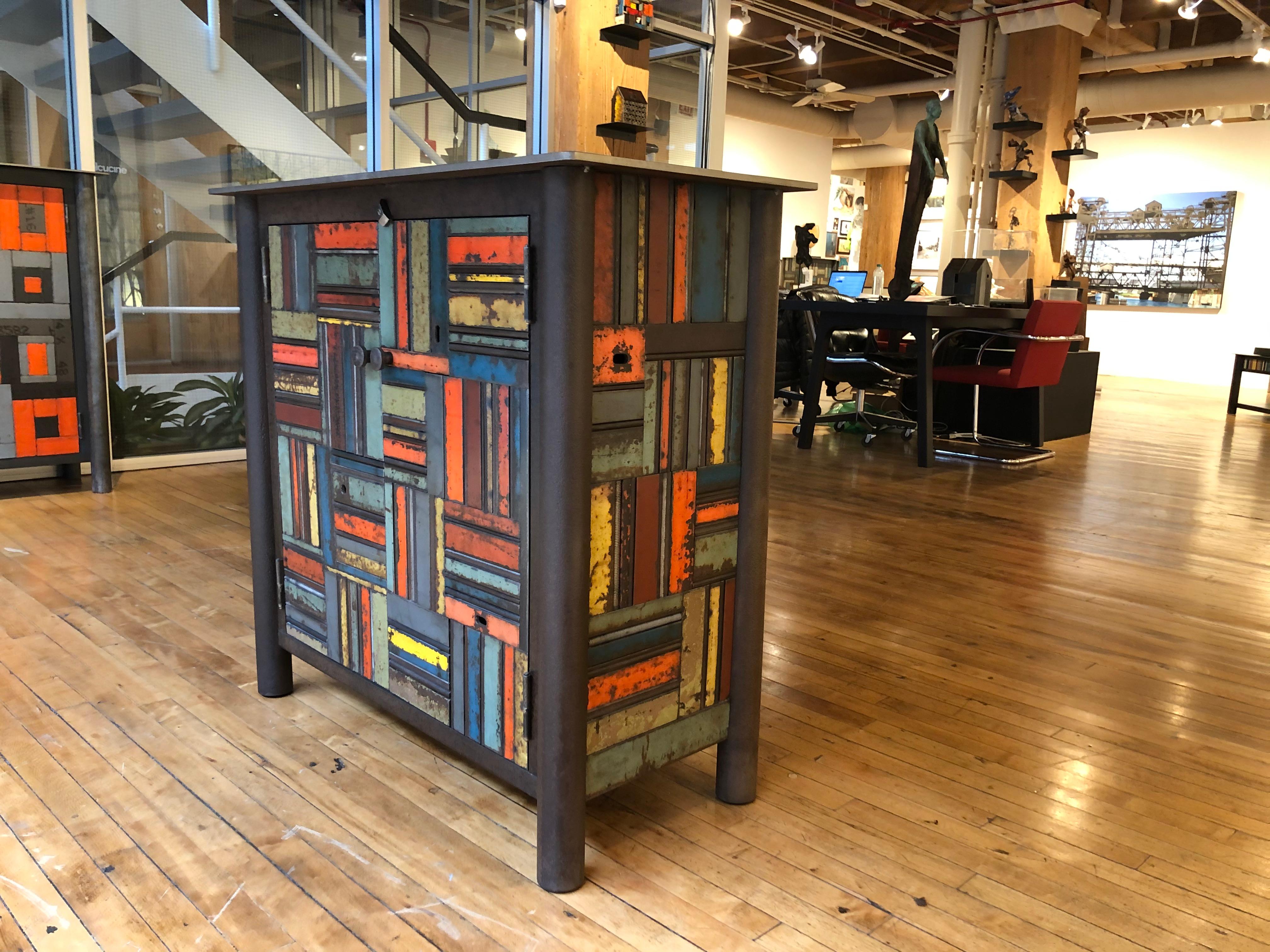This is a totally functional two door cupboard. It is created from natural rusted steel and found steel. The legs are made from salvaged pipe. The panels on the door fronts and sides are made from salvaged pieces of steel with the original paint and