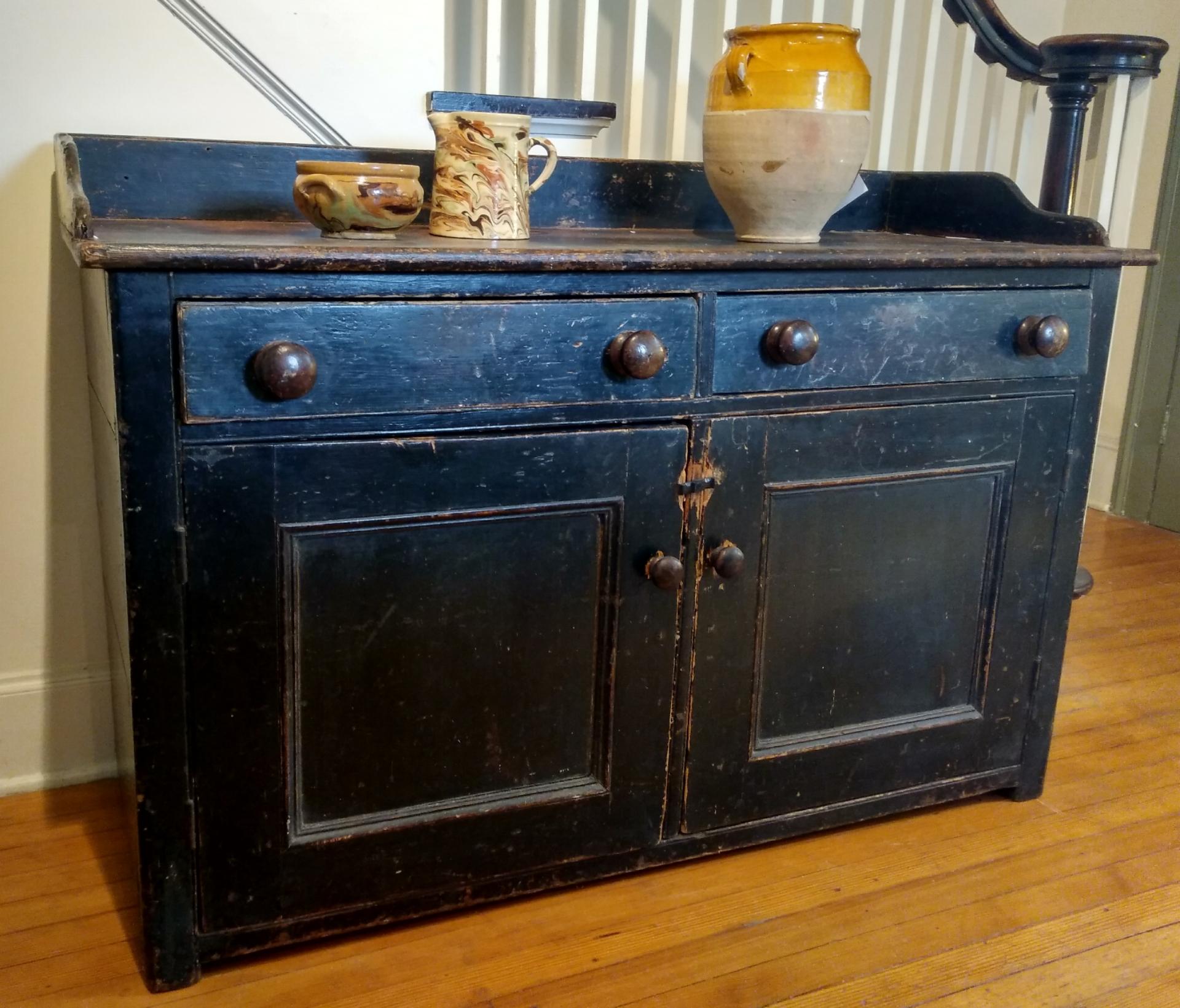 Original worn black paint and more worn tabletop, with original wooden knobs and a recessed shelf inside make this piece just about perfect. We love, love this two-door English buffet and the railing simple added to its unique look.
 