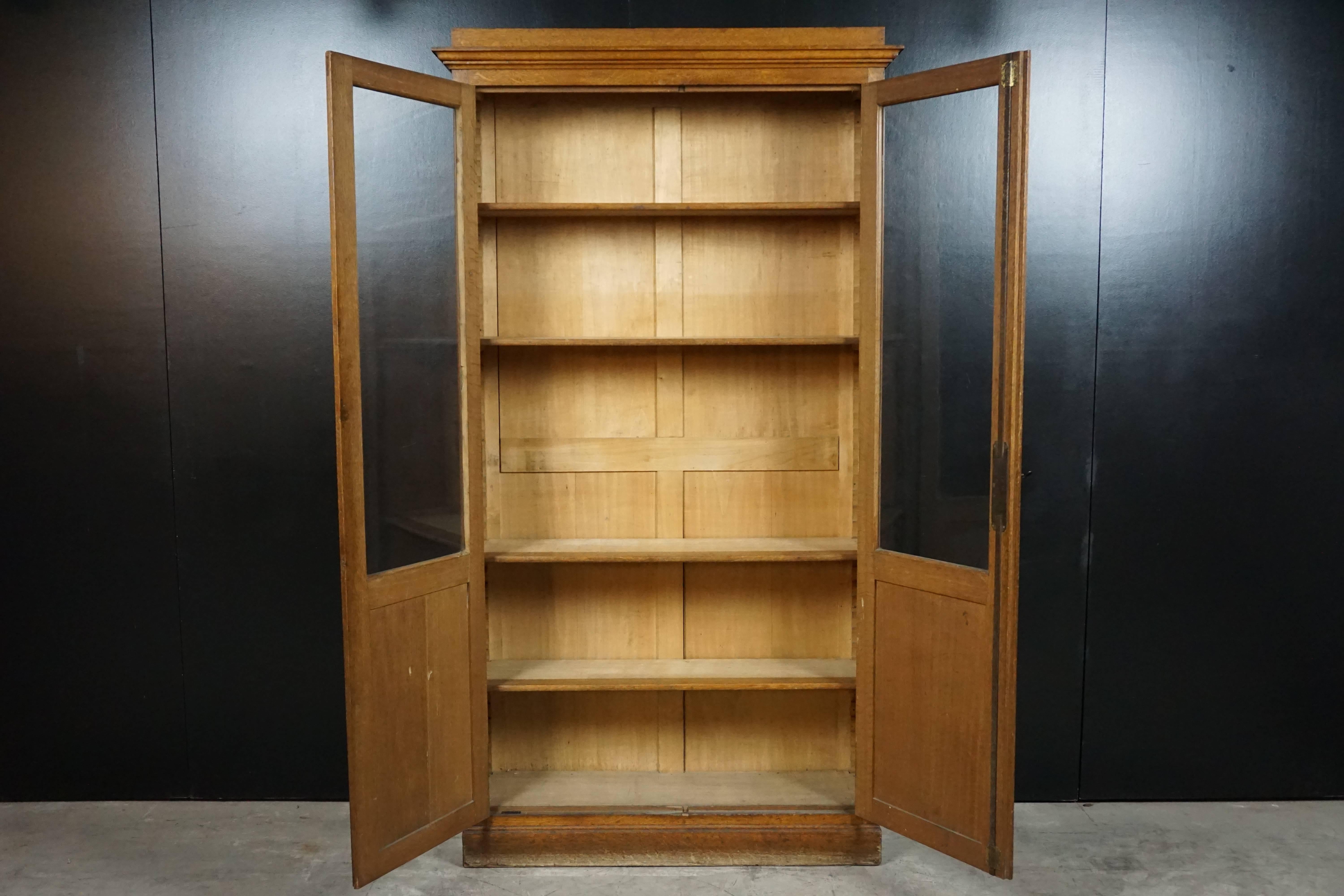 Two-door glass book case from France, circa 1930. Solid oak construction with adjustable shelving. Working lock with key Included.