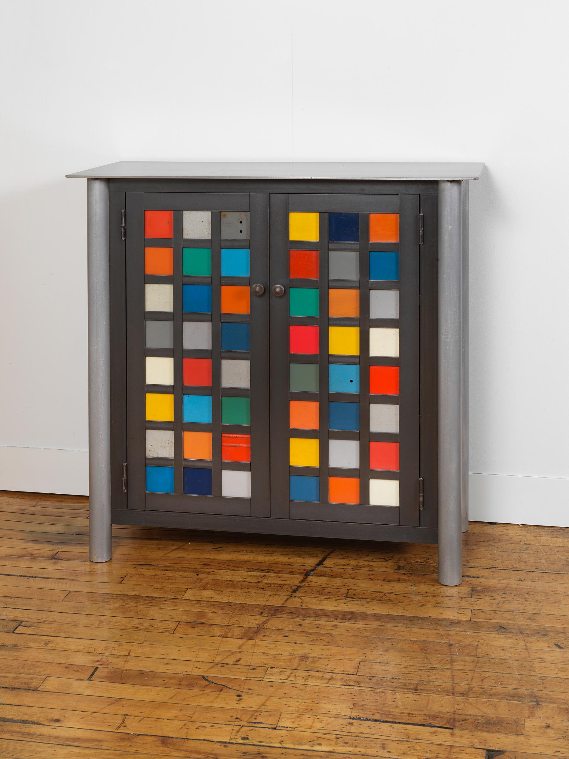 This totally functional cabinet with two interior shelves is created from hot-rolled steel and found painted panels. The panels on the door fronts and sides are created from blocks of painted salvaged and recycled steel. This unique custom piece is