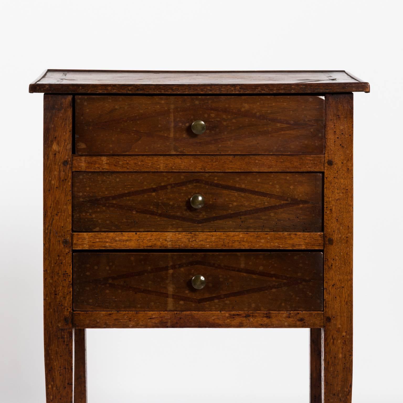 Three drawer French commode with square tapered legs and diamond inlay, circa 1820.
 