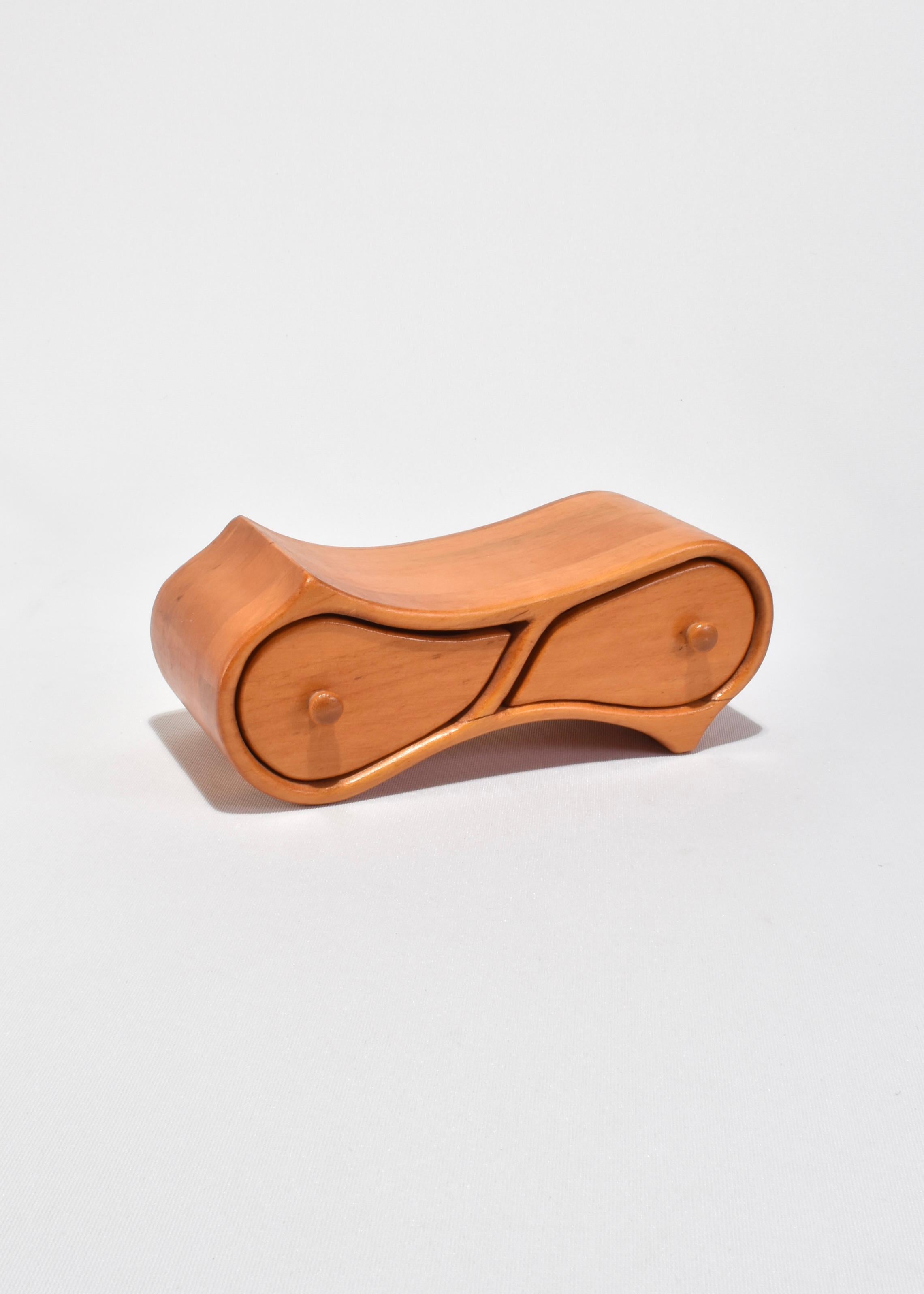 Small sculptural jewelry box crafted in bentwood with a fluid, curved silhouette. Features two side-by-side drawers with rounded pulls. Minimalist and organic in form—ideal for storing rings or other small keepsakes.