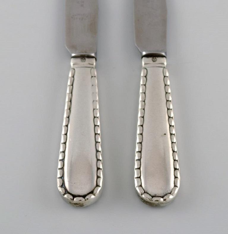 Two early Georg Jensen Rope fruit knives in silver, 830, and stainless steel. 
Dated 1915-1930.
Measure: length: 16.5 cm.
In excellent condition.
Stamped.
Our skilled Georg Jensen silversmith / goldsmith can polish all silver and gold so that