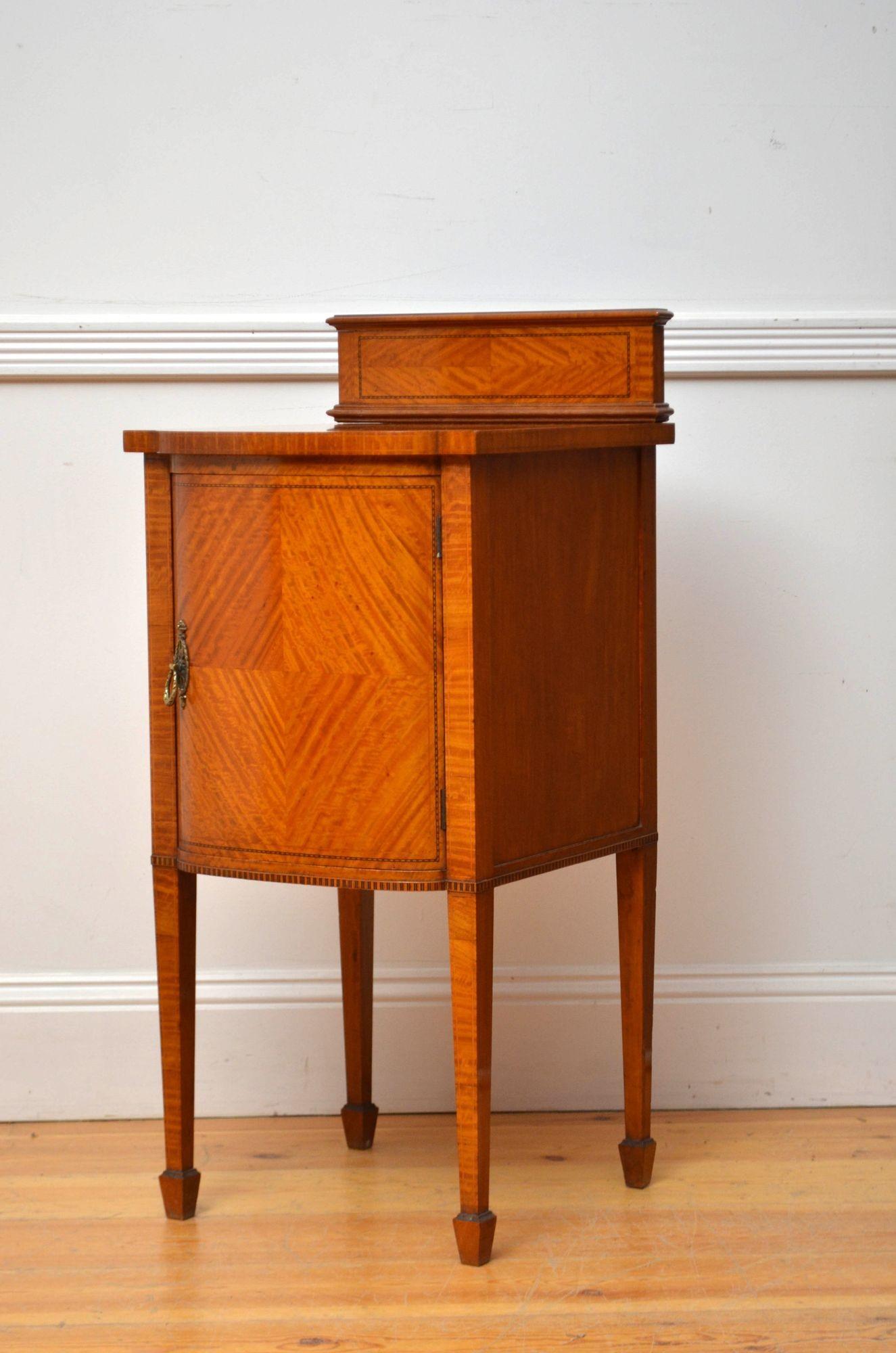 Two English Edwardian bedside cabinets.
K0499 Fine quality Edwardian satinwood bedside cabinet of bowed design, having moulded and inlaid upstand and quarter book matched veneered top with double inlay to the edge above inlaid cupboard door fitted