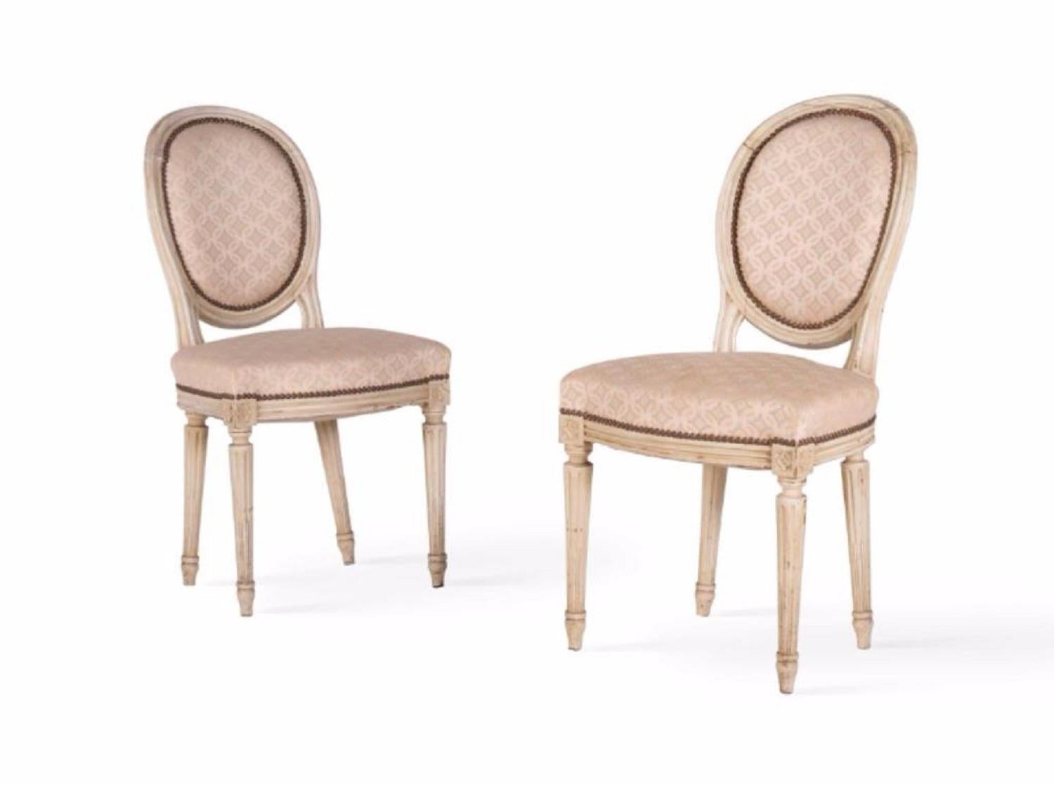 Two elegant antique chairs from France in Louis XVI style, circa 1860. These chairs are made of solid painted wood with curved frame and legs and have been reupholstered with a beige figured fabric. 'Rudente´' detail over the 'canelures' of the