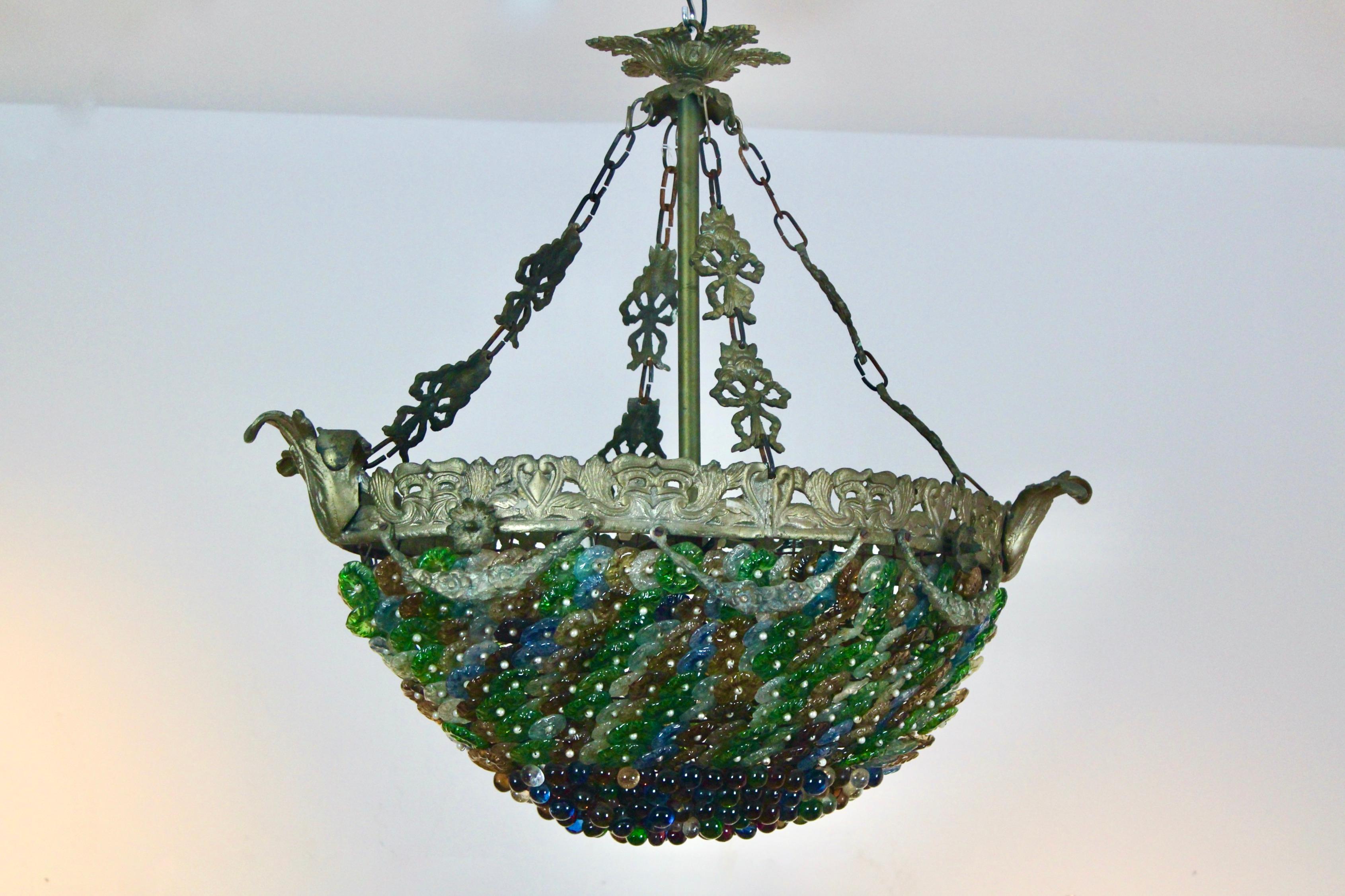 A very elegant neoclassical chandelier composed of diecast and colorful Italian Murano glass drops and flowers in many colors. Produced in Italy in the 1930s. Consisting of many transparent, green, white, amber, yellow, red and blue individually