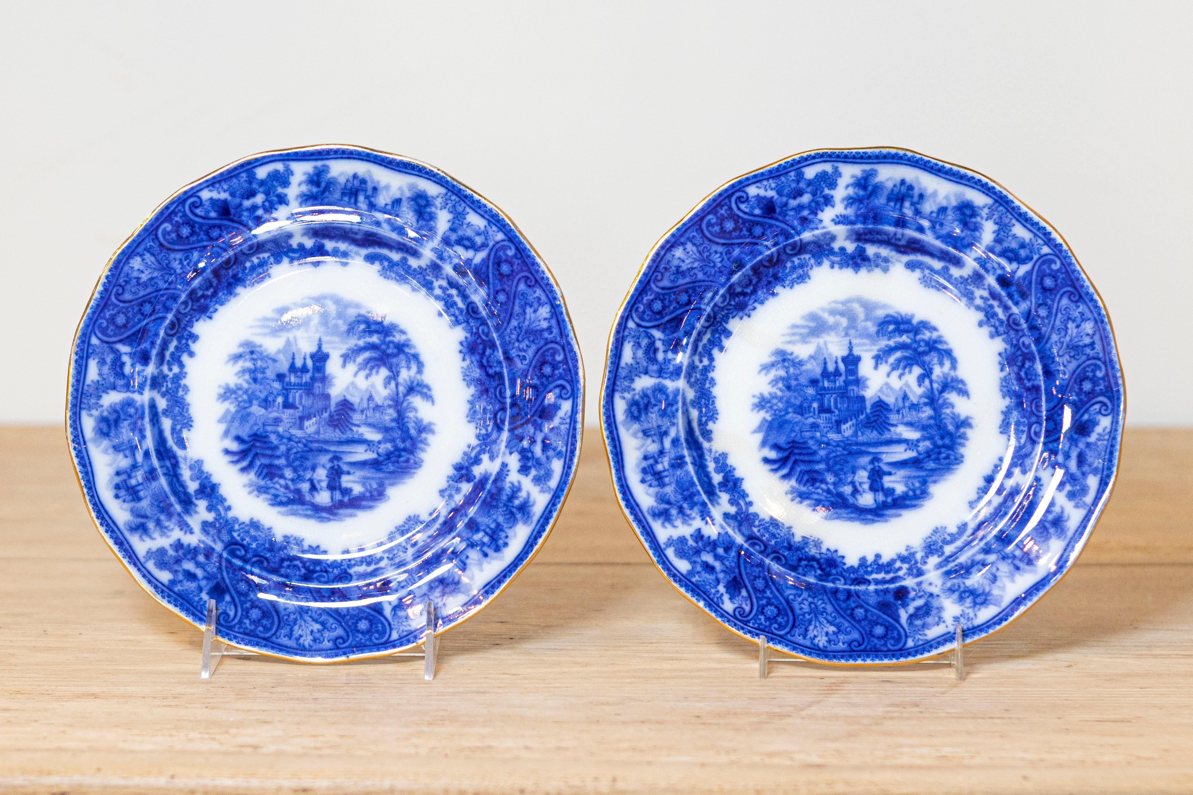Two English Burgess & Leigh Middleport Nonpareil pattern flow blue plates from the late 19th, early 20th century, with outdoor scenery and gold rim. They are priced and sold individually. Born in the Middleport pottery during the turn of the century