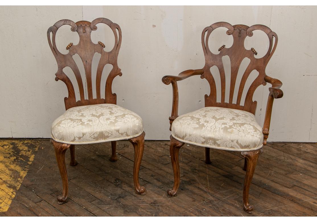 With openwork shaped crest rails with carved centers with tassels, over fan shaped splats. Scrolled arms and cabriole legs in front, splayed ones at back. The seats upholstered in a white damask fabric (very clean). 
Measures: H. 36 1/2