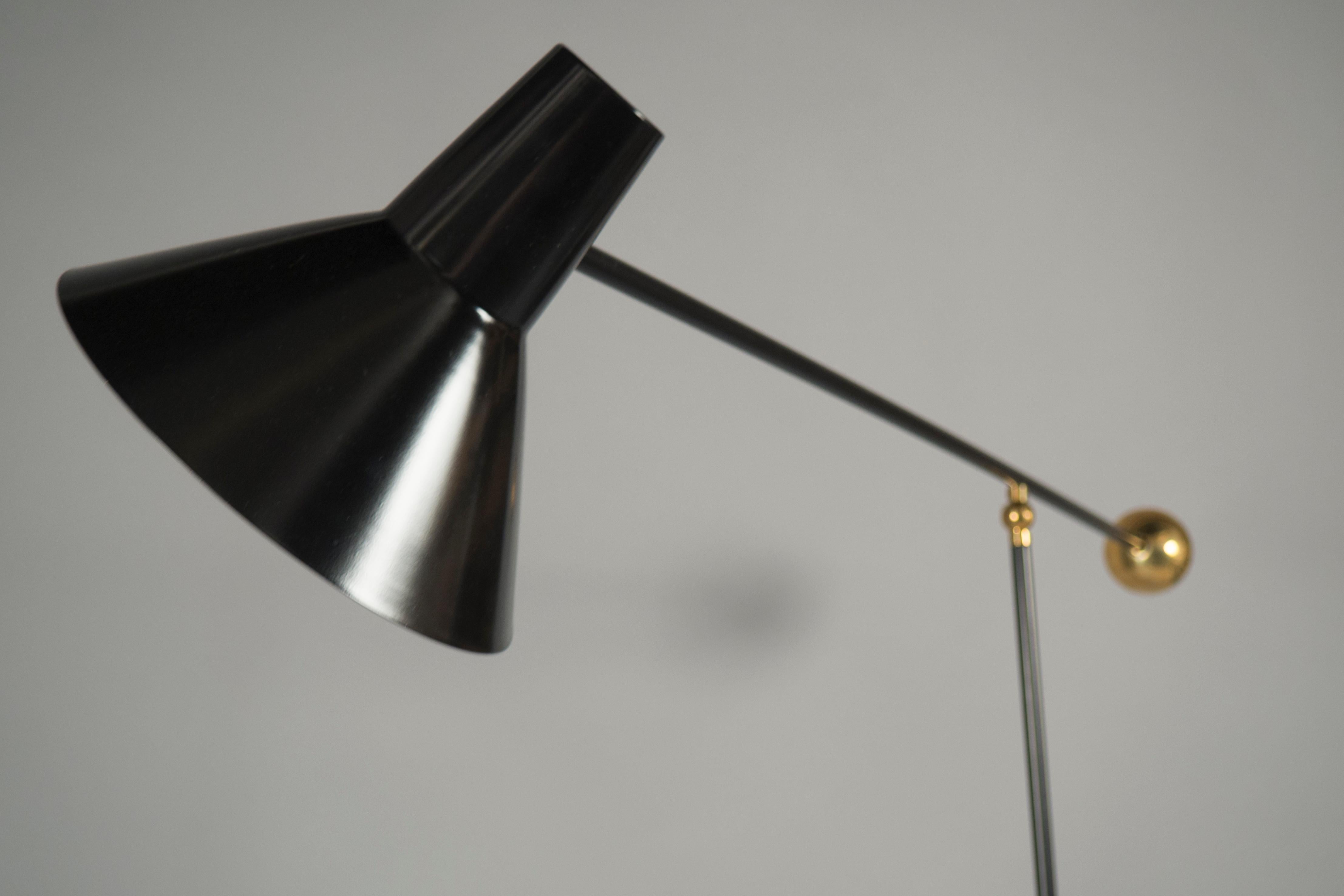 Black painted and polished brass floor lamp, featuring a conical shade balanced by a counterweight.


Size is adjustable:
Height 61-88”, width 22”, depth 18-52”.