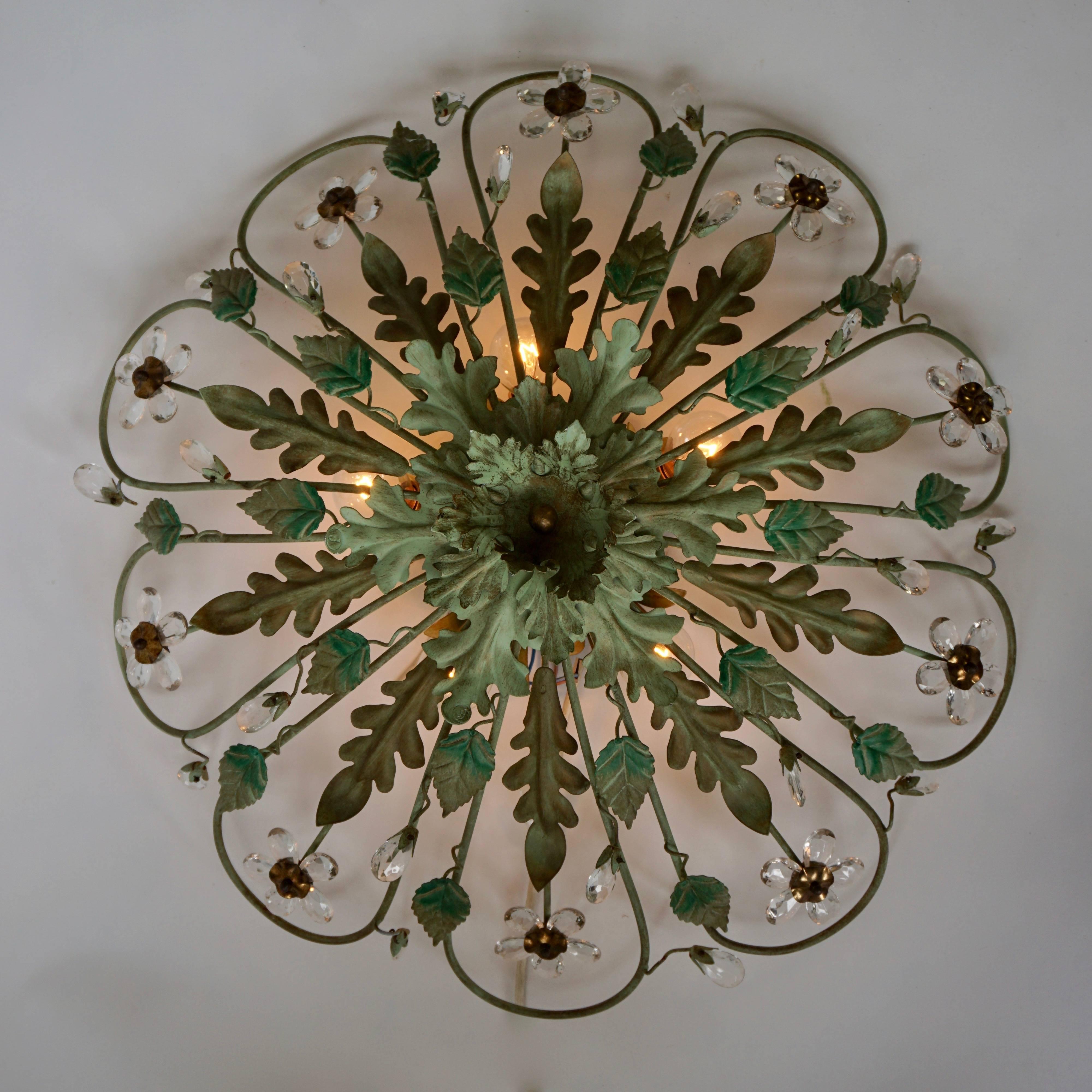 One painted metal flush mount light with glass flowers. The light creates a warm and cozy light with a distinct light right underneath the shade. The lamp features five lights source of max 60W.
