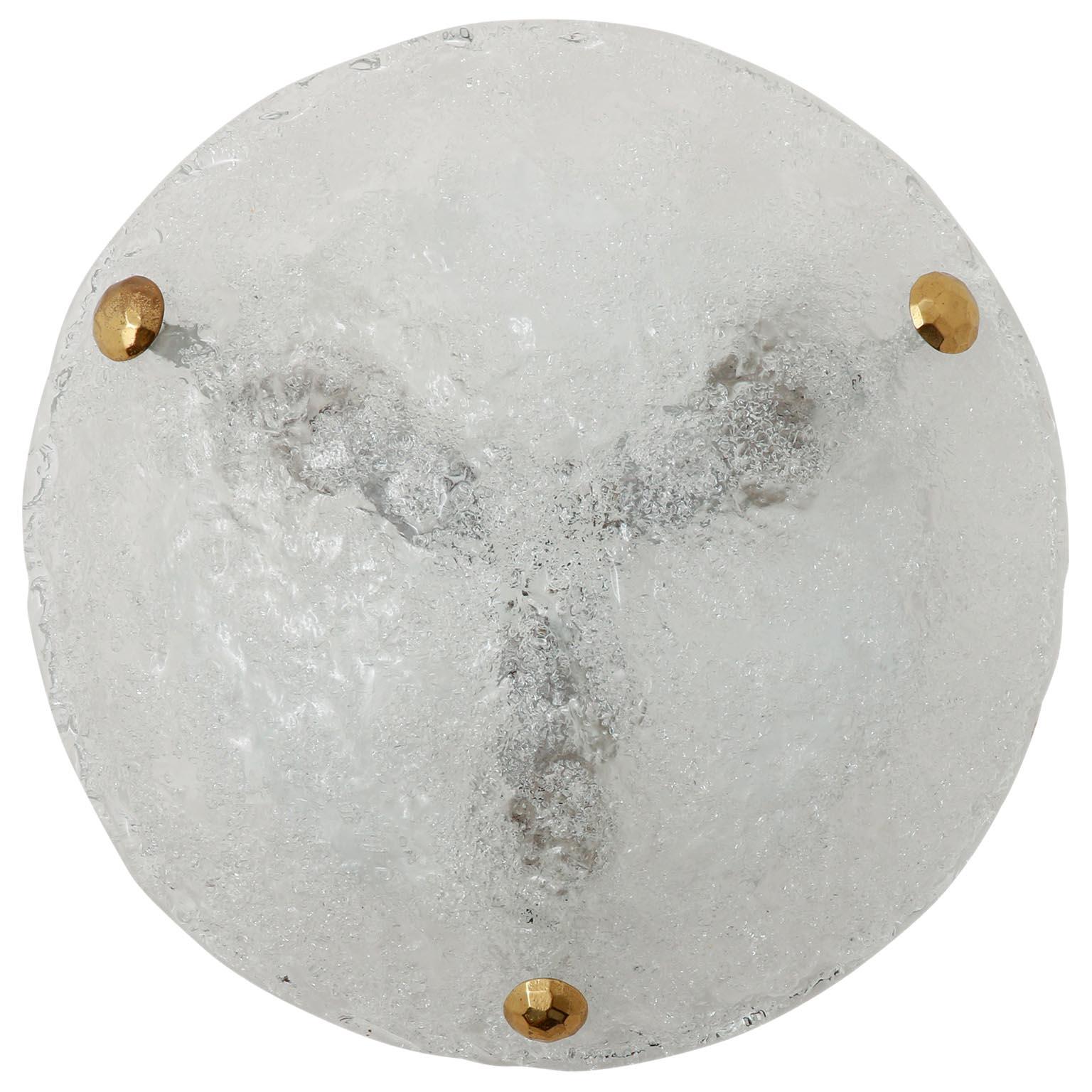 One of two round ice glass light fixtures by Hillebrand, Germany, manufactured in midcentury, circa 1970 (late 1960s or early 1970s). 
A textured and clear glass with an icy structure is mounted with three large brass bolts on a white enameled metal