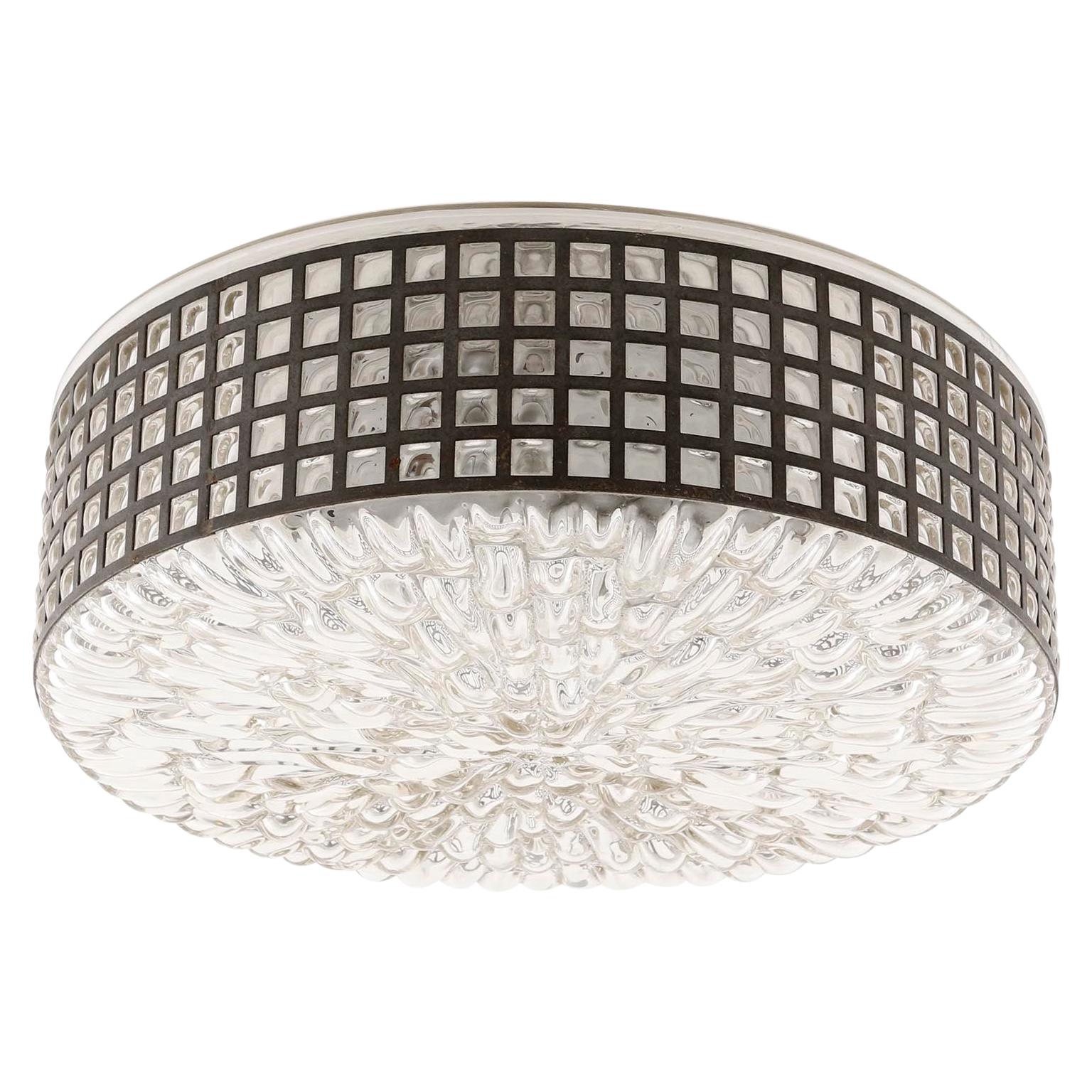 One of two fantastic textured glass light fixtures by Rupert Nikoll, Austria, Vienna, manufactured in midcentury, circa 1950s-1960s.
They can be used as ceiling or wall lamps.
The glass has been hand blown throw a perforated round metal belt which