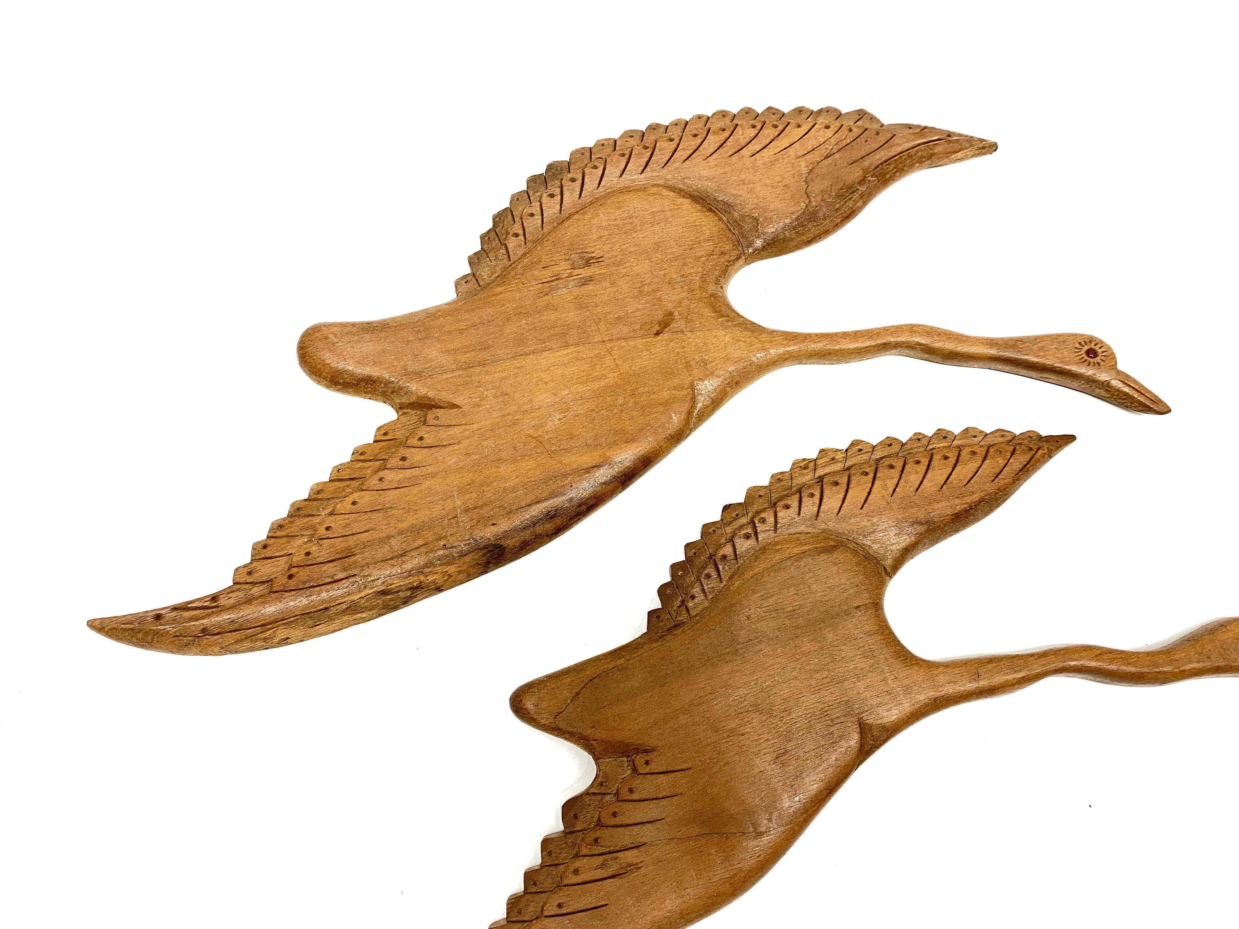 Two beautiful vintage wood carved flying bird themed statues. They would make a beautiful ornament on each wall. They are made of wood and have glass eyes. Made in the 1950s it displays the joy of that great era with a bold, yet classy statement.