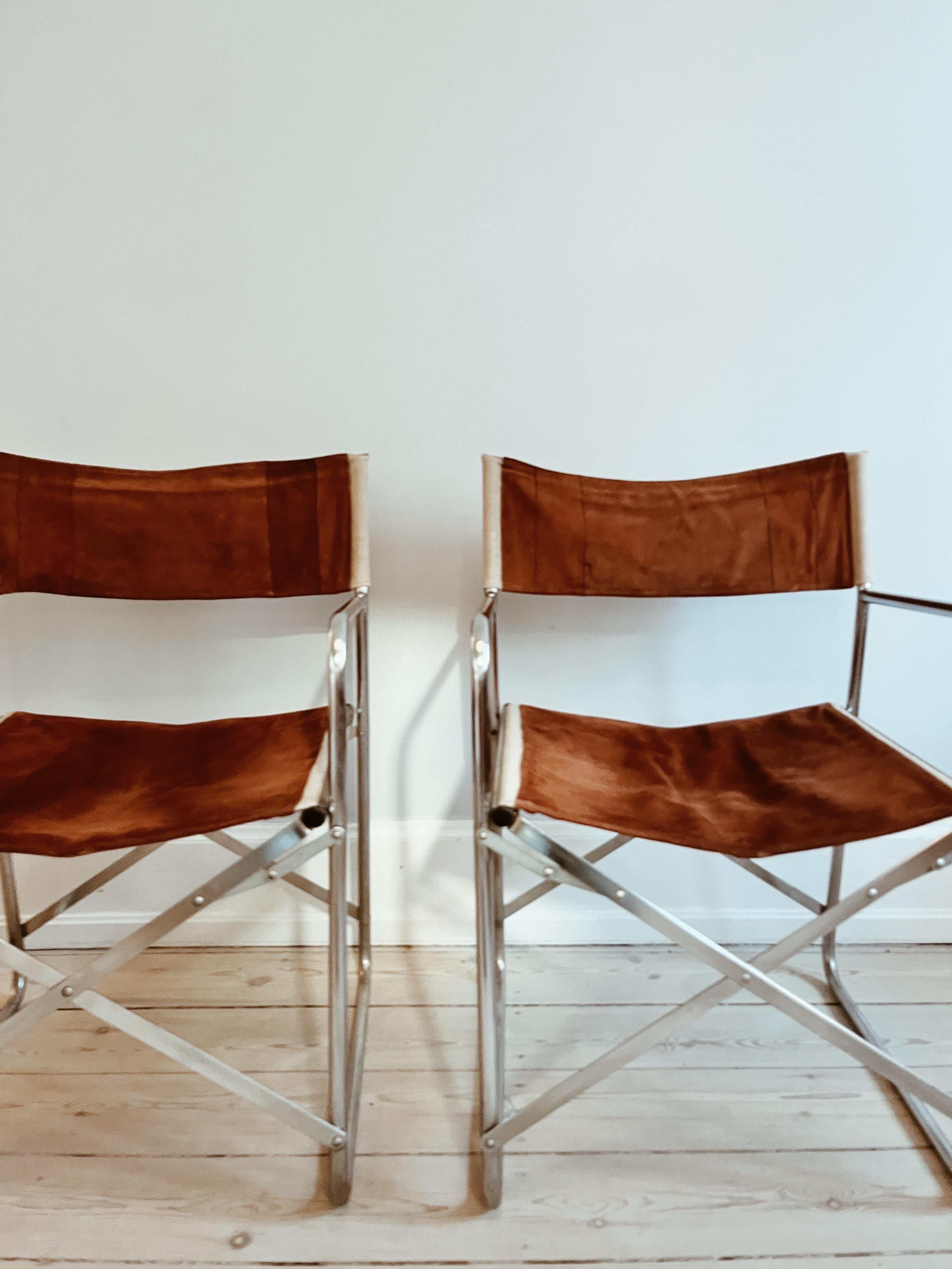 Two instructor/folding chairs in chocolate brown suede, canvas and frame in chrome. 

The chairs are from the 1970s/1980s and in great condition. Nice bright kanvas-details on the brown suede. 

The leather is steamed and cleaned and appears in