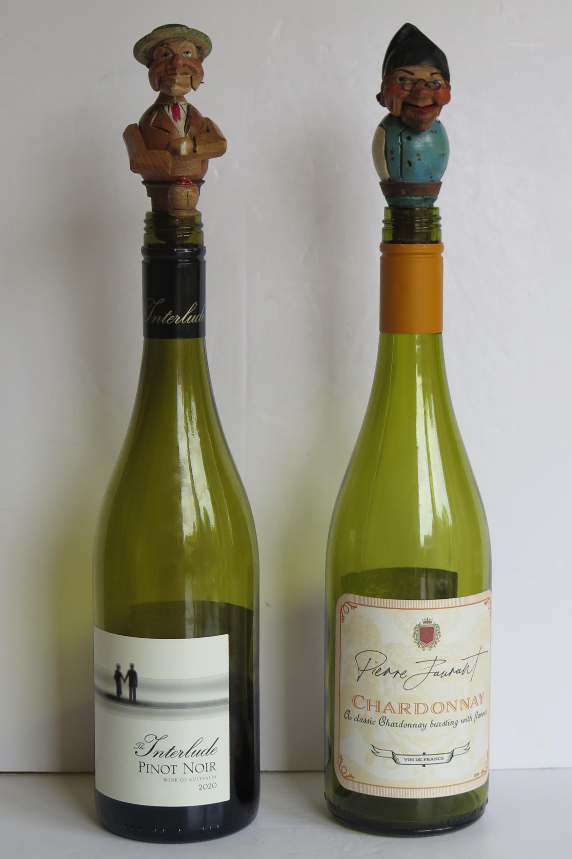 These are a different Pair of Folk art, hand made and painted, articulated, Wine bottle Stoppers, made in mid Europe, probably Germany and dating to the early 20th century, circa 1930 or earlier.

Both stoppers are hand carved of wood, then hand