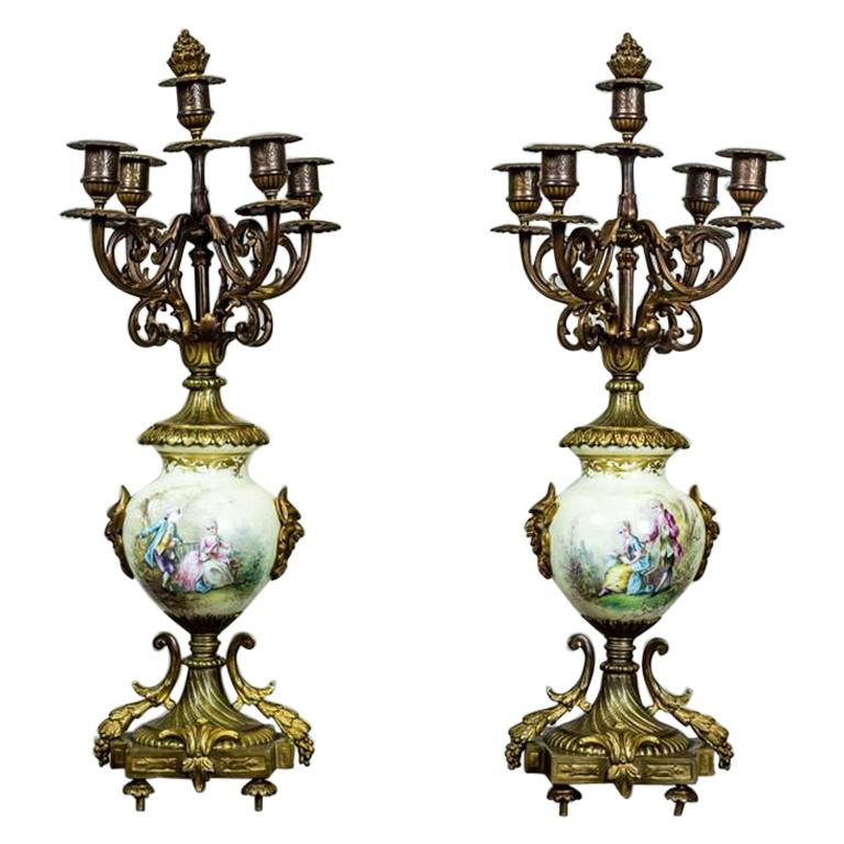 Antico, due candelabri a quattro bracci con dettagli in porcellana e ottone, XIX secolo