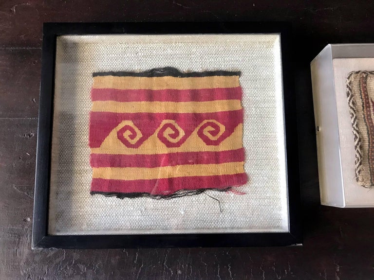 Two small fragments of pre-Columbian textiles in shadow box frames. Both have strong geometrical patterns in the style of Nazca culture, located in the southern coast of nowadays Peru, which flourished from 100BC to 800AD. They appear to be woven