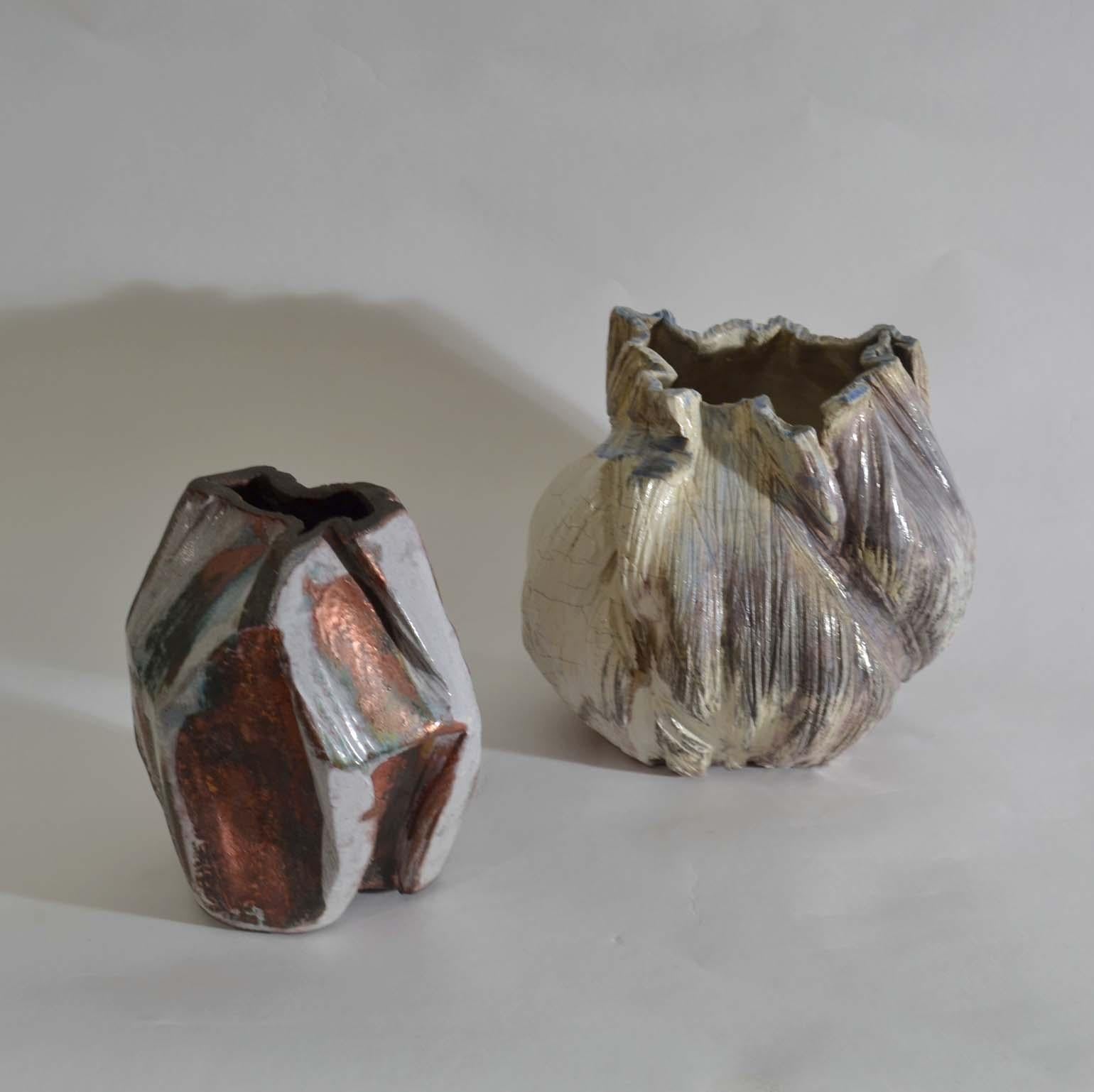 Two organic hand formed vases have different scalloped edged detailing. Scratched and moulded onto the surface are layers of maroon, wine, cardinal red, blue colors. The over glaze helps accentuates its bulbous forms from all perspectives. Signed