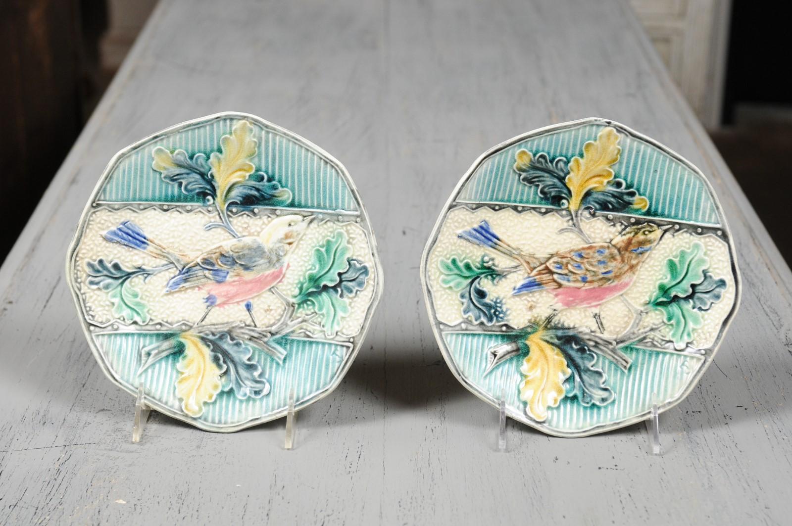 Two French Majolica decorative plates from the 19th century depicting a bird perched on an oak tree branch, priced and sold individually. Born in France during the dynamic 19th century, each of these two Majolica plates features a scalloped edge,