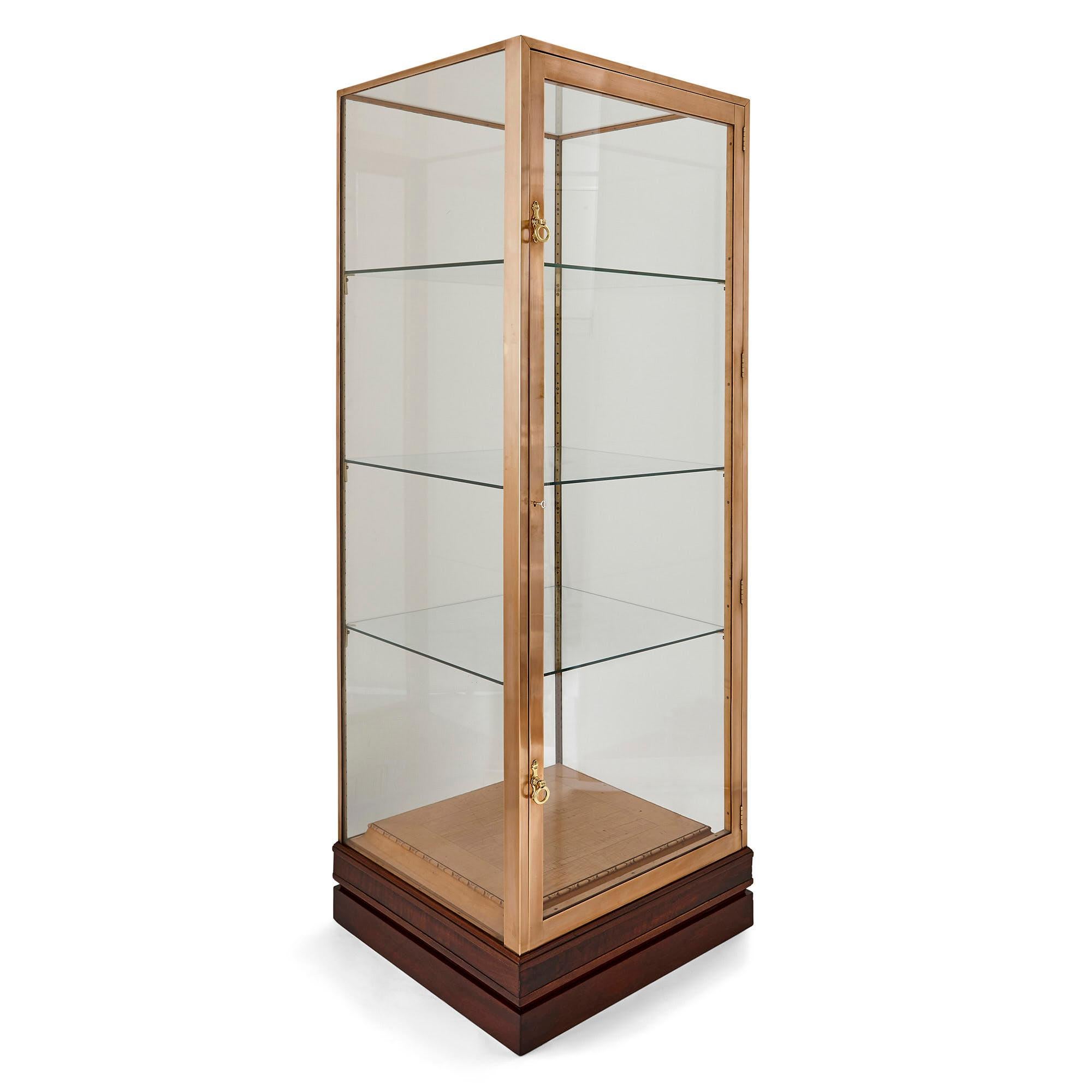 This pair of vitrines (display cabinets) are characterized by a restrained design typical of late period French Art Deco design. The vitrines sit on dark wooden bases. Wood is found again, though of a lighter colour, on the bottom of the interior,
