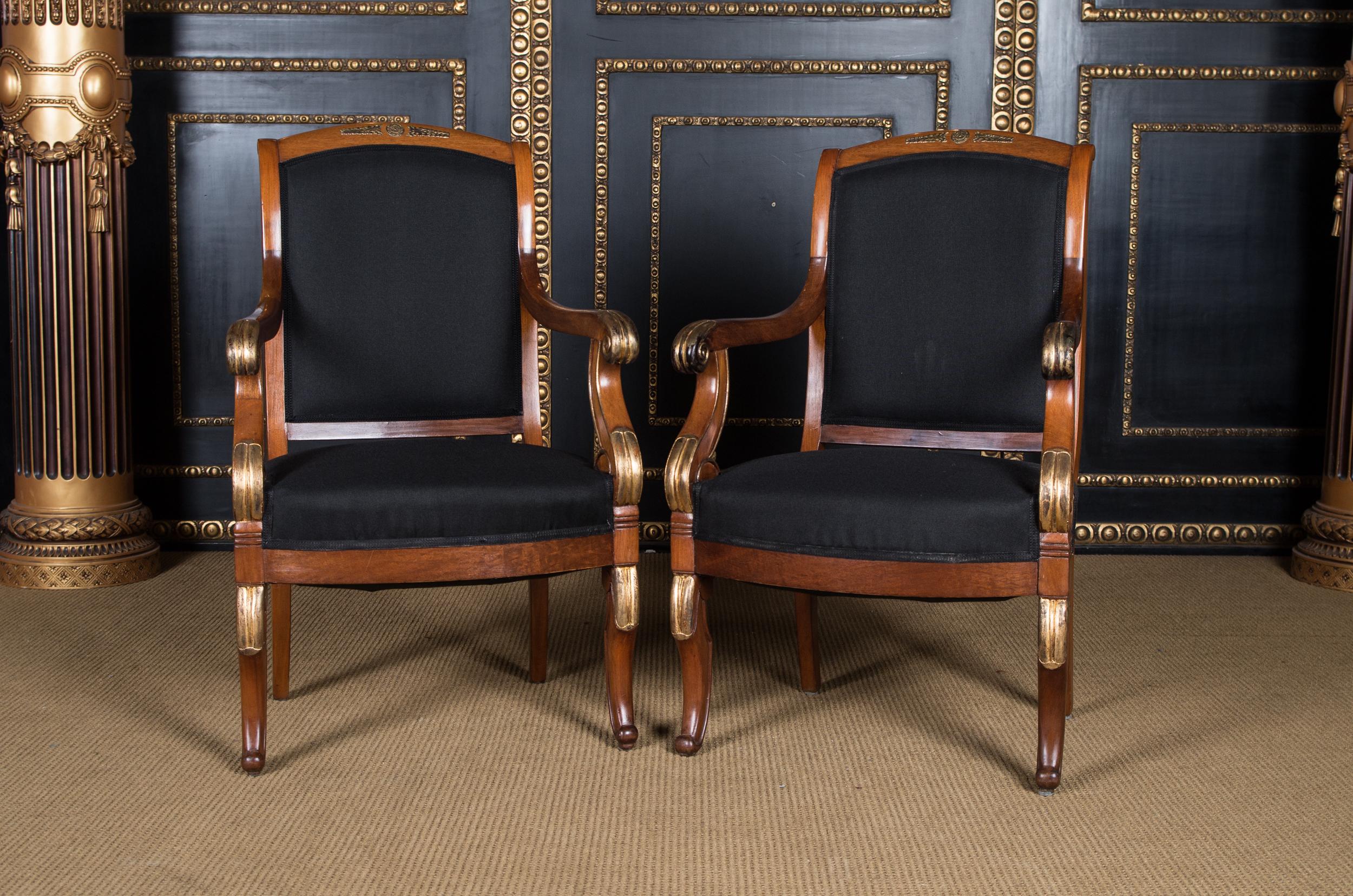 Two French Empire armchairs circa 1860 mahogany

Massive mahogany partly carved. Curved frame on curly legs. Curved supports for slightly rising armrests ending in curled volute. High rectangular, slightly curved backrest frame with wide end. The