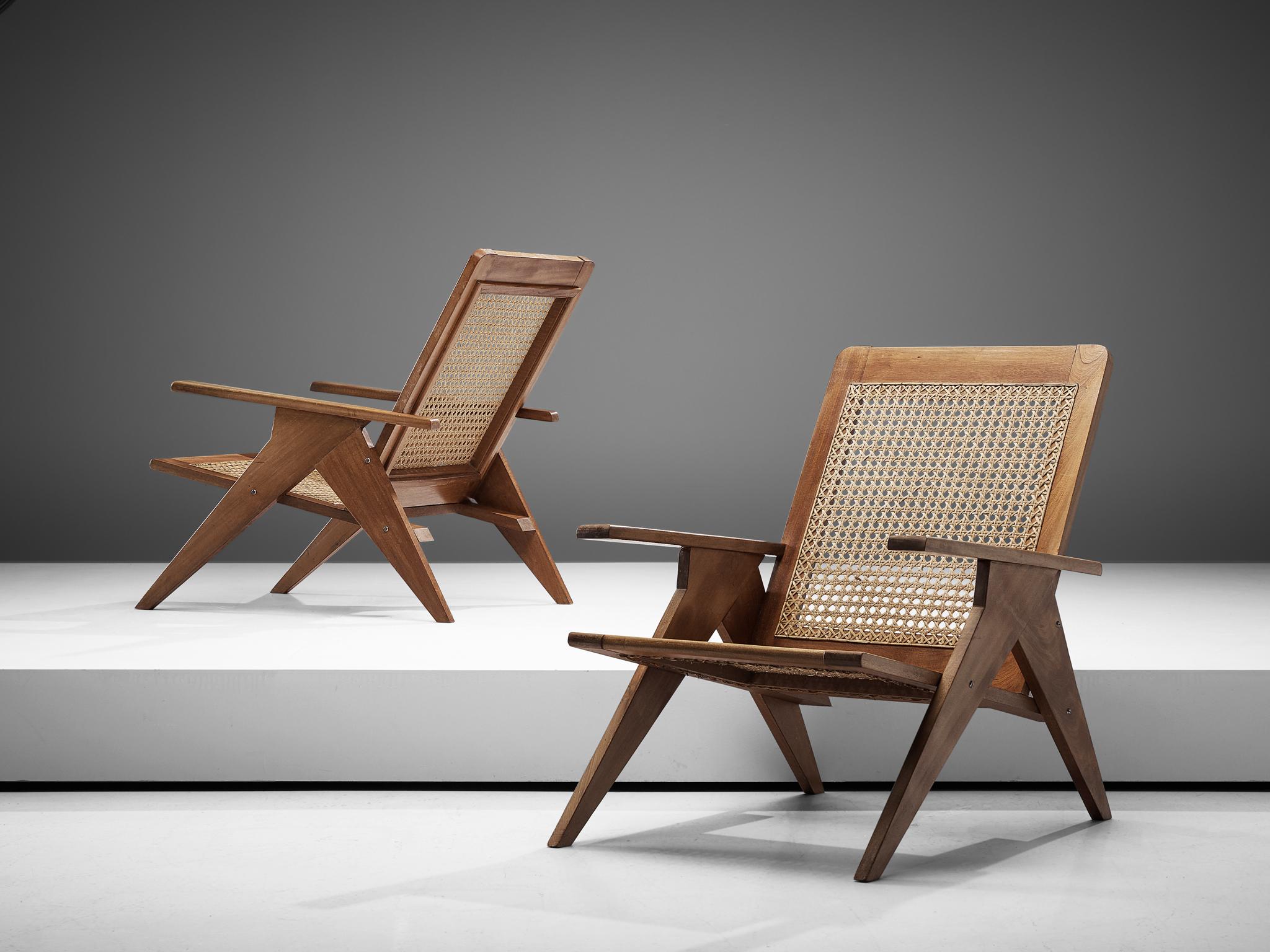 Set of 2 lounge chairs, cane and mahogany, France, 1960s

This set of French lounge chairs shows wonderful, sculptural details. The straight armrests and the tapered, triangular shaped legs combine beautifully with its woven cane seat. The chairs