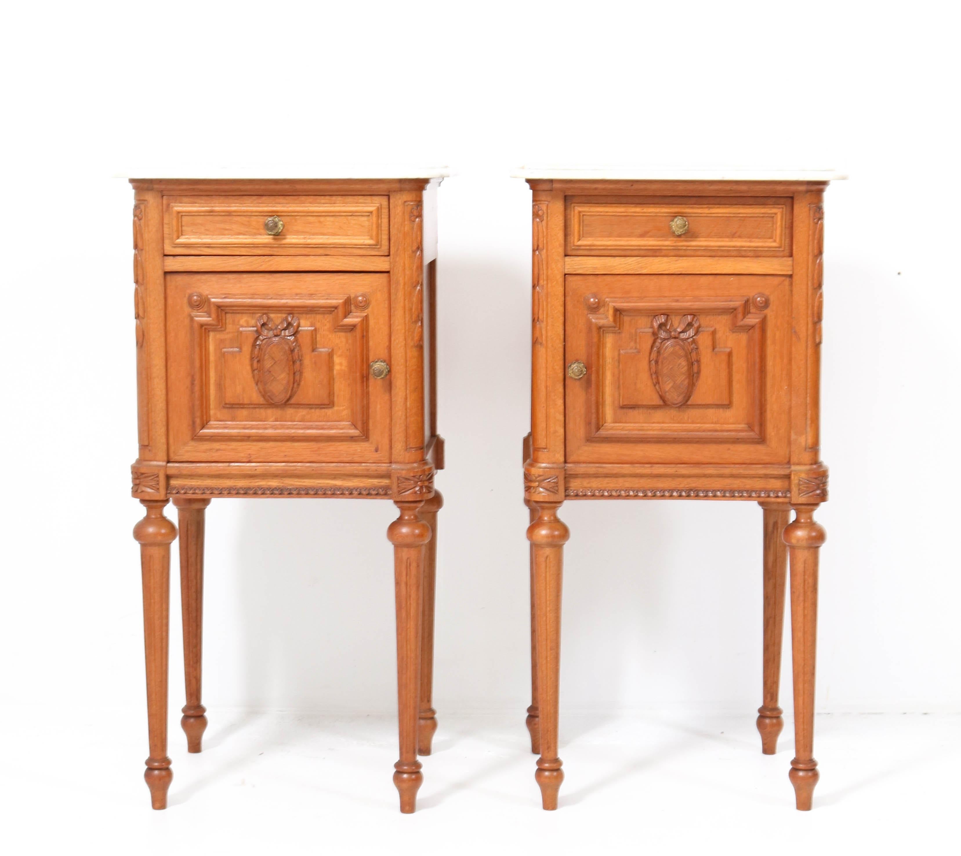 Stunning pair of Art Nouveau nightstands or bedside tables.
Striking French design from the 1900s.
Solid oak with original brass knobs on doors and drawers.
Original marble tops,please note one top has been broken but has been
professionally