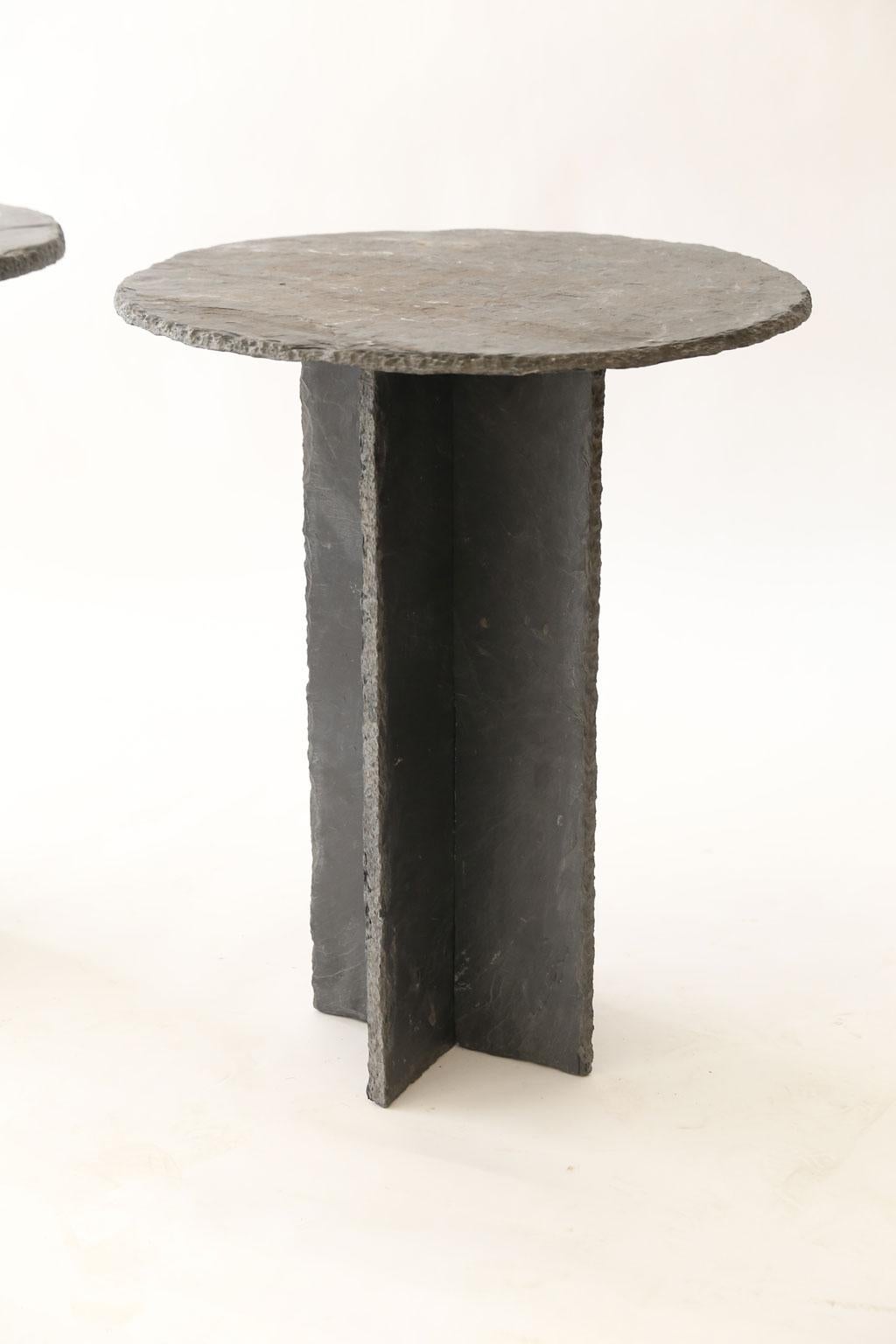Two French tables d'ardoise, vintage round top slate side tables each with two-piece slate base that crosses and connects in centre.