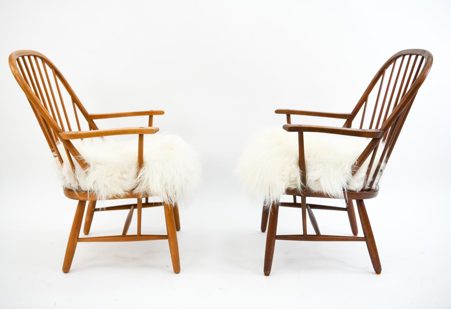 Two unusual and impressive Fritz Hansen armchairs, attributed to Palle Suenson & Gustav Adolf Schneck. These chairs feature spindle backs with fluffy lambswool seats for a wonderfully comfortable contrast. Beautiful and sculptural these chairs are