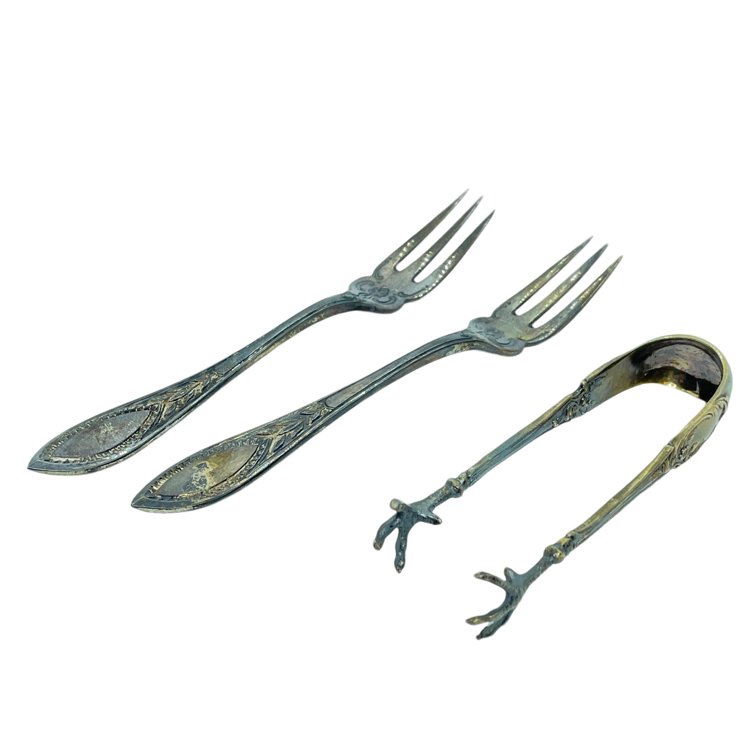A pair of beautiful Art Nouveau fruit forks and a sugar tong. These serving pieces are in a rare and antique design, made by a manufacturer in Leipzig Germany. Made of 800 coin silver, it will make a nice addition to any table. The Weight of the