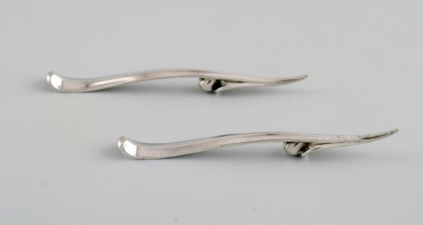 Two Georg Jensen nut / cocktail picks in sterling silver. Ornamental design. 
Model 68B. Dated 1933-44.
Length: 11.8 cm.
In excellent condition.
Stamped.
Our skilled Georg Jensen silversmith / goldsmith can polish all silver and gold so that it