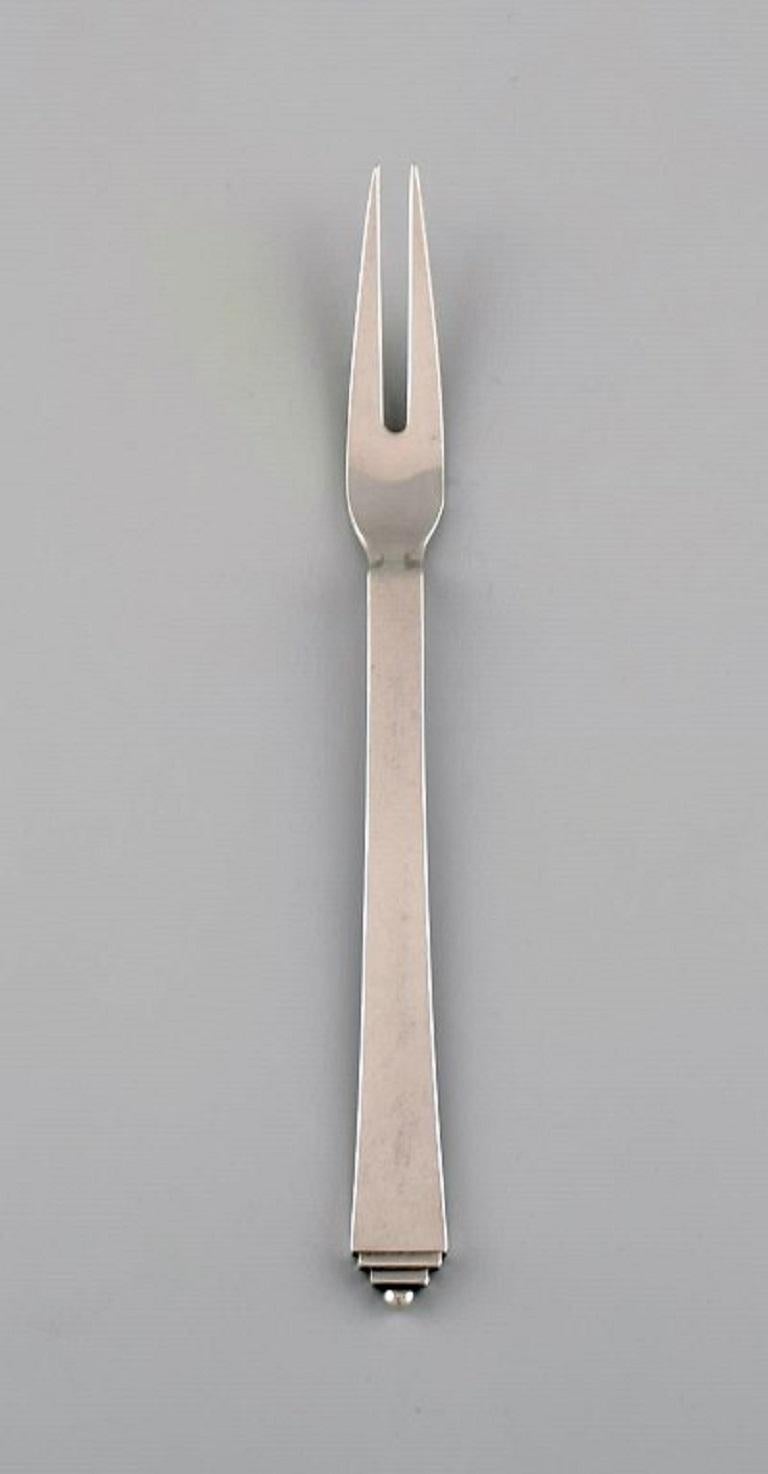 Two Georg Jensen Pyramid cold meat forks in sterling silver. 1930s.
Length: 17.5 cm.
In excellent condition.
Stamped.
Our skilled Georg Jensen silversmith / goldsmith can polish all silver and gold so that it appears new. The price is very