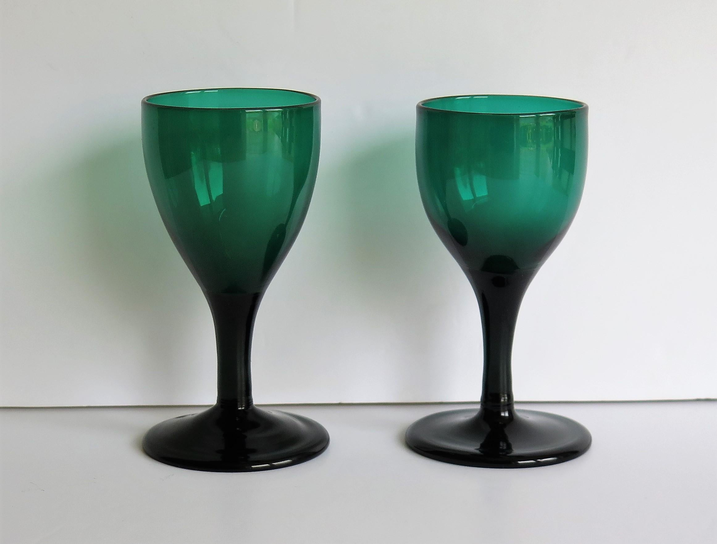 Es handelt sich um zwei (sehr nahe beieinander liegende) gute englische Weingläser, mundgeblasen, Bristol Green, Bleiglas, aus dem späten 18. Jahrhundert, George 111rd Periode, ca. 1790.

Jedes Glas hat eine gezogene tulpenförmige Schale, die sich