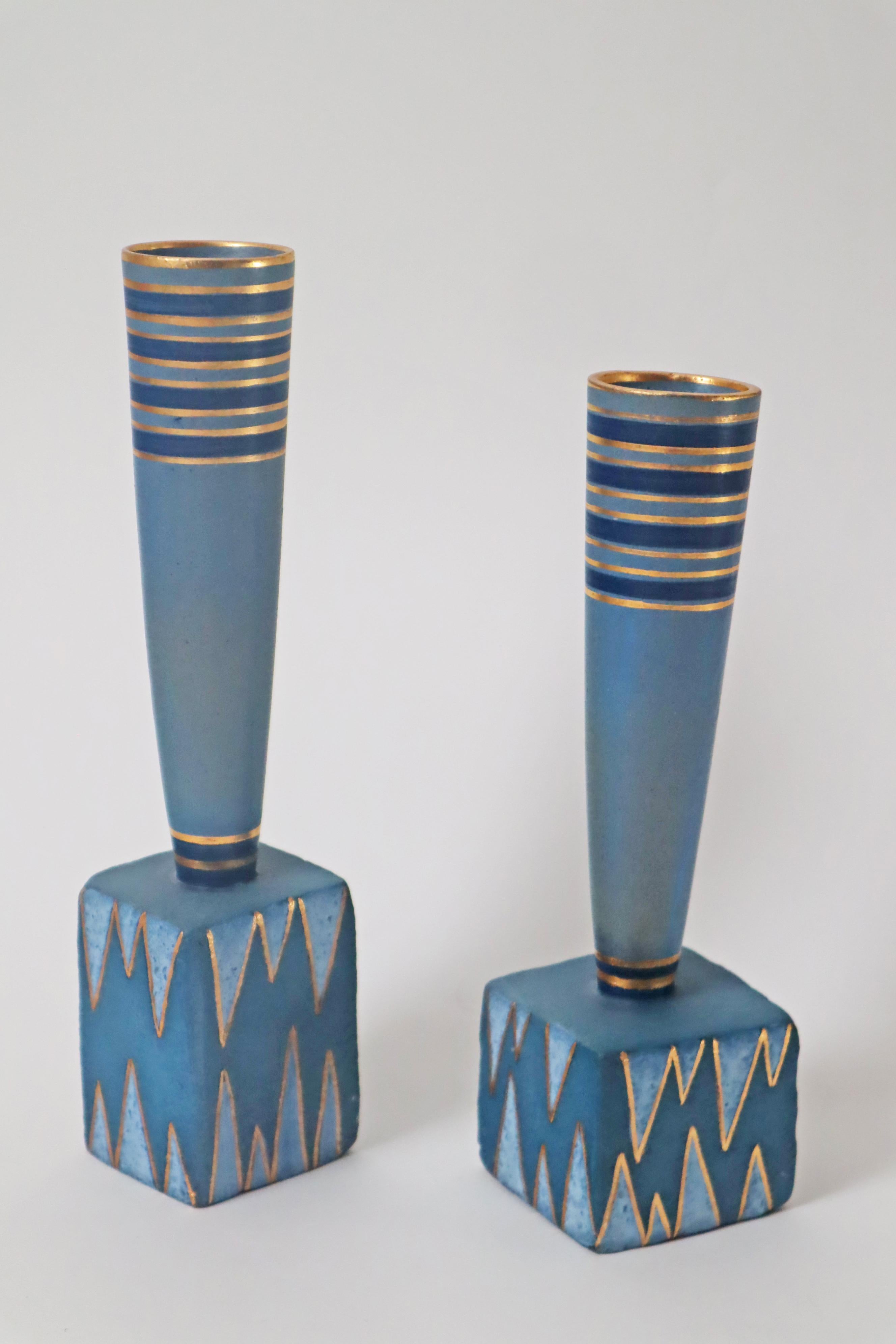 Eccezionale, postmoderna in un'eccellente combinazione di colori, lo splendido blu turchese e l'oro caratterizzano questa meravigliosa coppia di vasi. Il vaso leggermente più grande ha un'altezza di 29 cm e una larghezza e profondità di 7,5 cm,