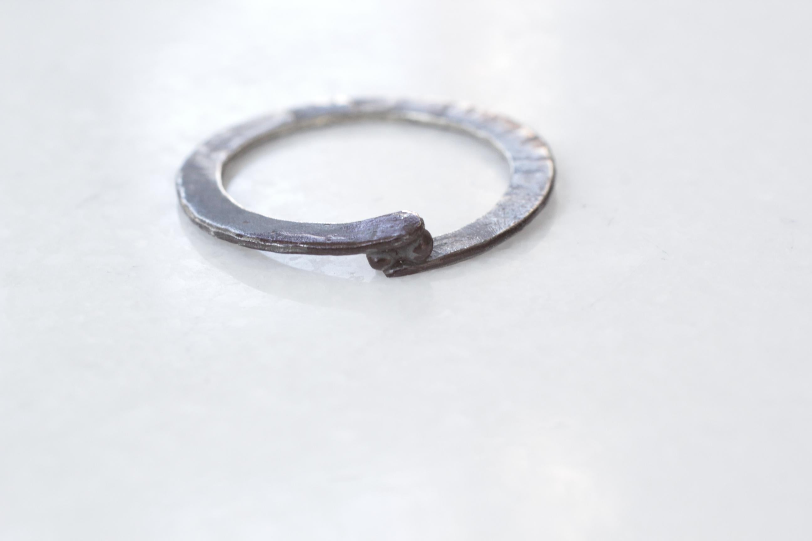 Simplicity With A Twist Holding Two Granules, contemporary design.
This listing is for a fashion ring in oxidized or blackened sterling silver, measuring 1mm wide by 3mm thick.

Process: This striking ring is first hand forged in 21k gold, then cast