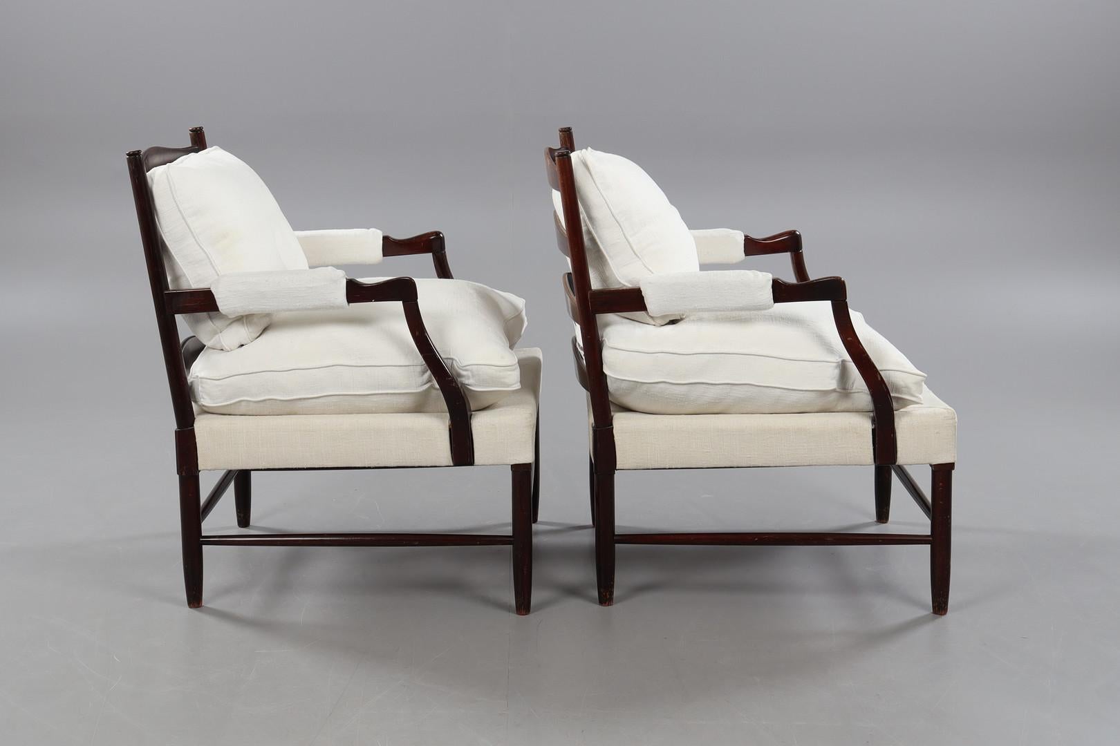 Die beiden Gripsholm-Sessel, entworfen von Arne Norell, sind wahre Schmuckstücke der Eleganz und Funktionalität des skandinavischen Designs. Die aus Buchenholz gefertigten Sessel verkörpern die für nordische Möbel charakteristische Schlichtheit und