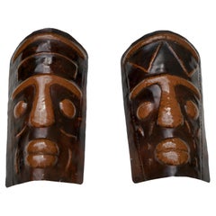 Deux appliques en cuivre martelé en forme de masques africains