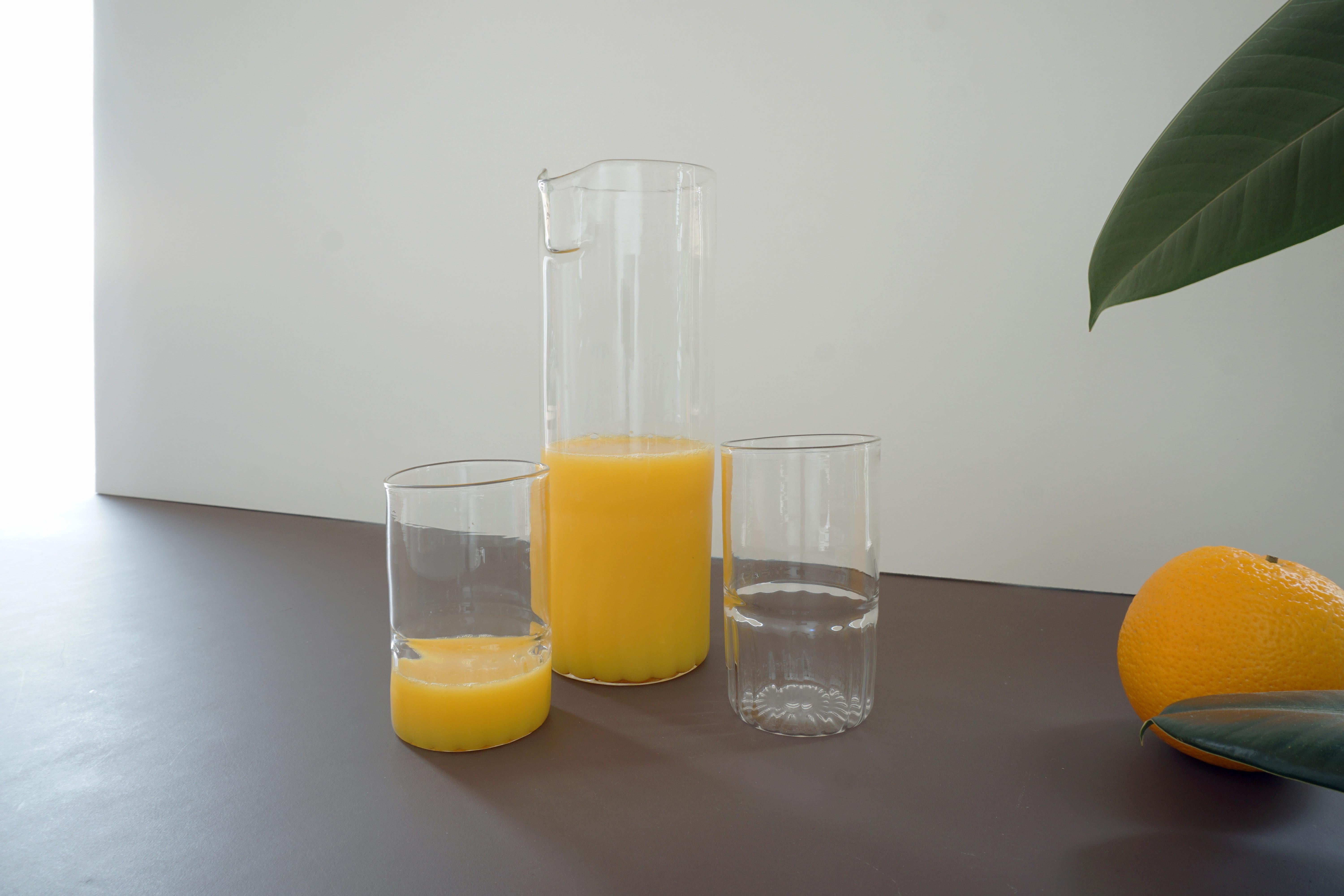Set of two tumblers with carafe / pitcher. 
Each piece is hand blown in borosilicate glass also knows as Pyrex. Each piece is unique with its own character.

Materials: 
Borosilicate glass

Dimensions: 
Tumblers 
5cm x 5cm x 9cm 
2