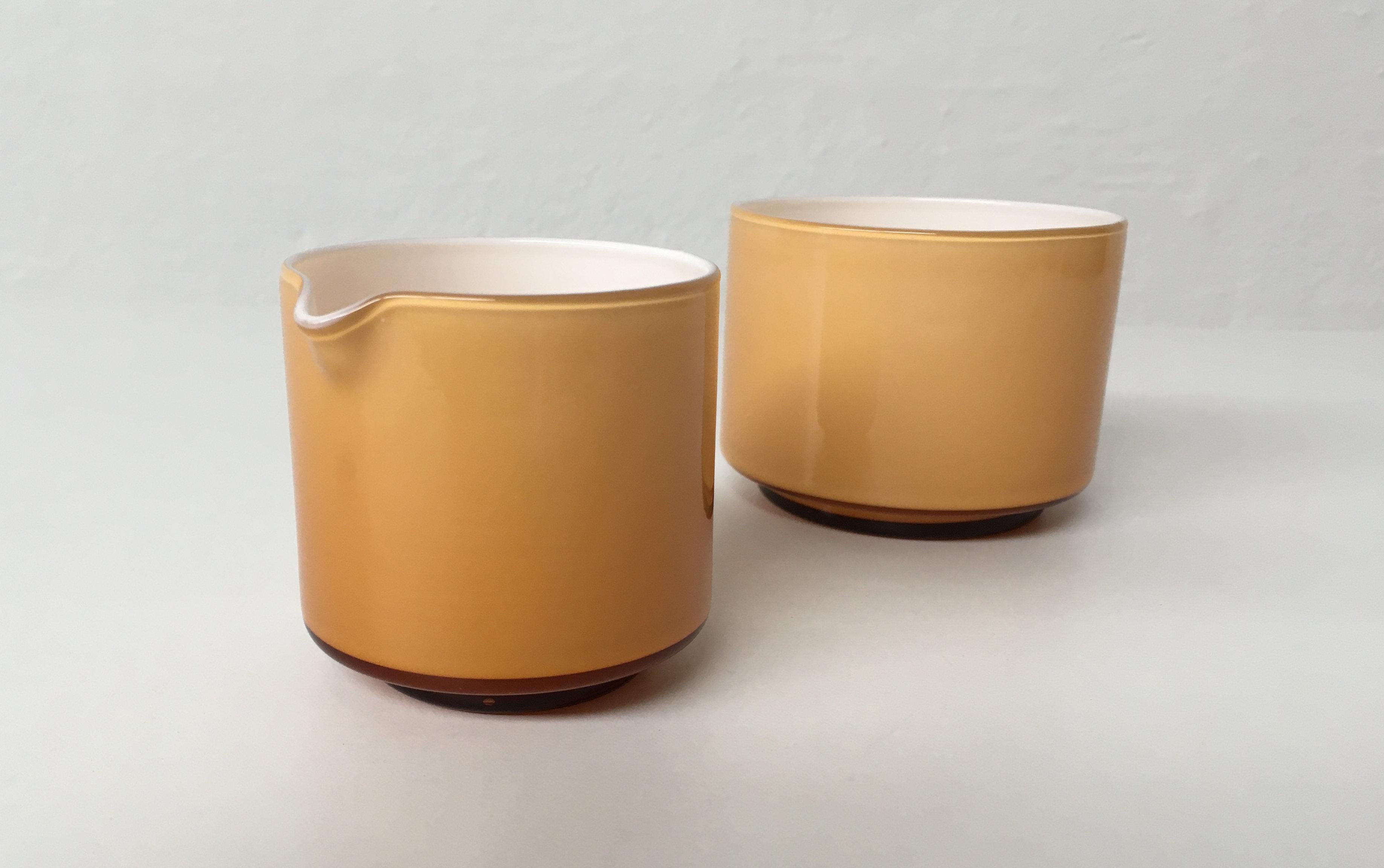 Set of honey-colored creamer and sugar bowls in handblown opaline glass, designed by Michael Bang and produced by Holmegaard in the 1970s.

The well designed set with it´s 1970´s colors is in very good condition.

Michael Bang (1942-2013) was