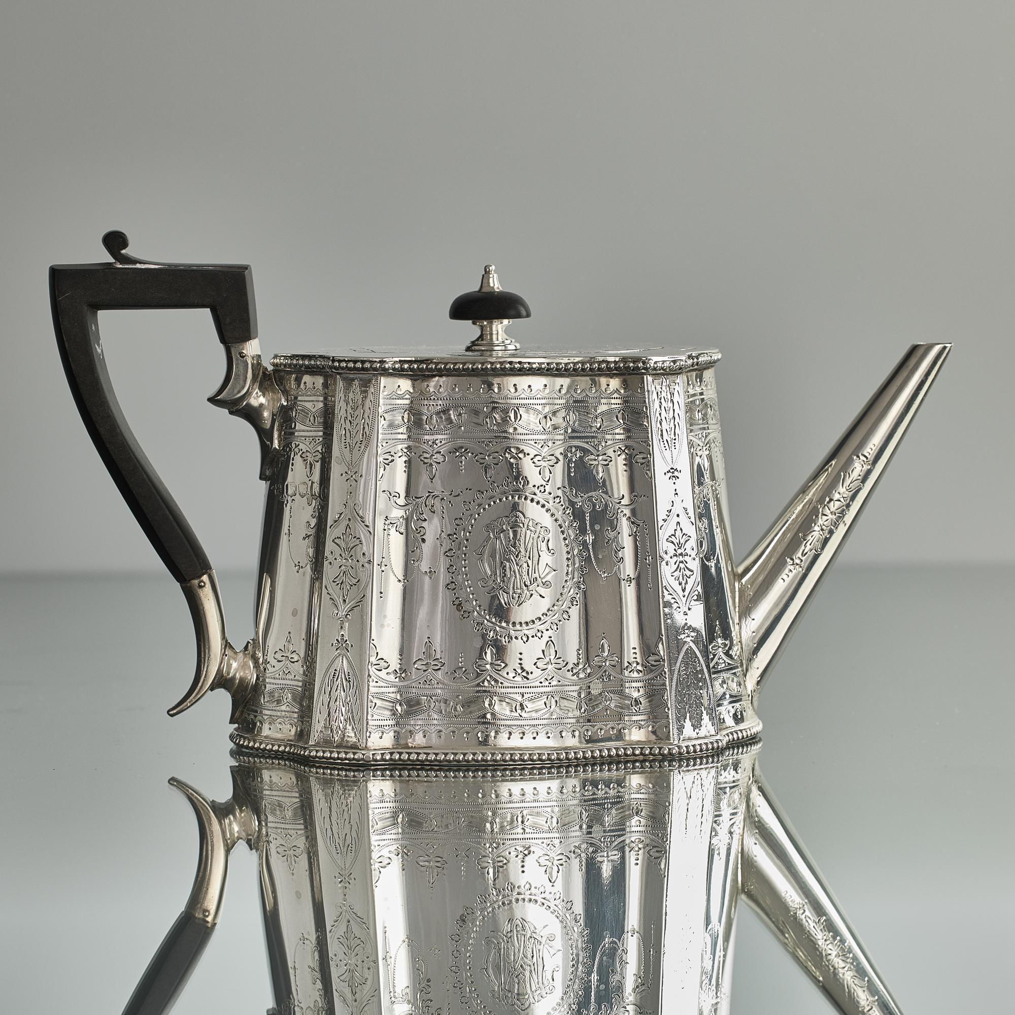 Late Victorian silver teapot of panelled, can-shaped form and decorated with fine hand engraving around the entire body and cover. The cover is fitted with a flush-mounted jeweller's hinge - a sign of quality - and is surmounted by a detachable