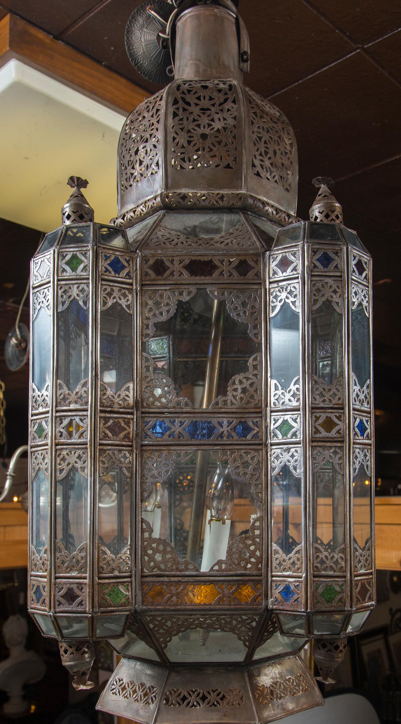 In the Moroccan or Islamic style, they can be sold individually or as a pair. The price indicated in this listing is for one. Small panes of colored glass, and larger ones of clear glass, Pierced brass structure. Within is a hanging 4 light