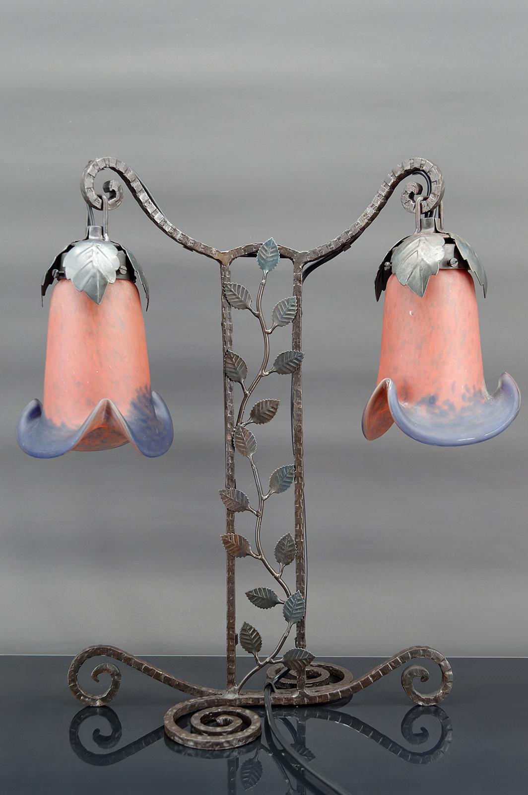 Two-headed lamp in wrought iron by Muller.

Art Deco, France, Circa 1920.

Floral theme.
Wrought iron base depicting a climbing plant.
Pink and blue tulips.

2 lights.

In very good condition, new electricity.

Dimensions:
height 48 cm
width 40