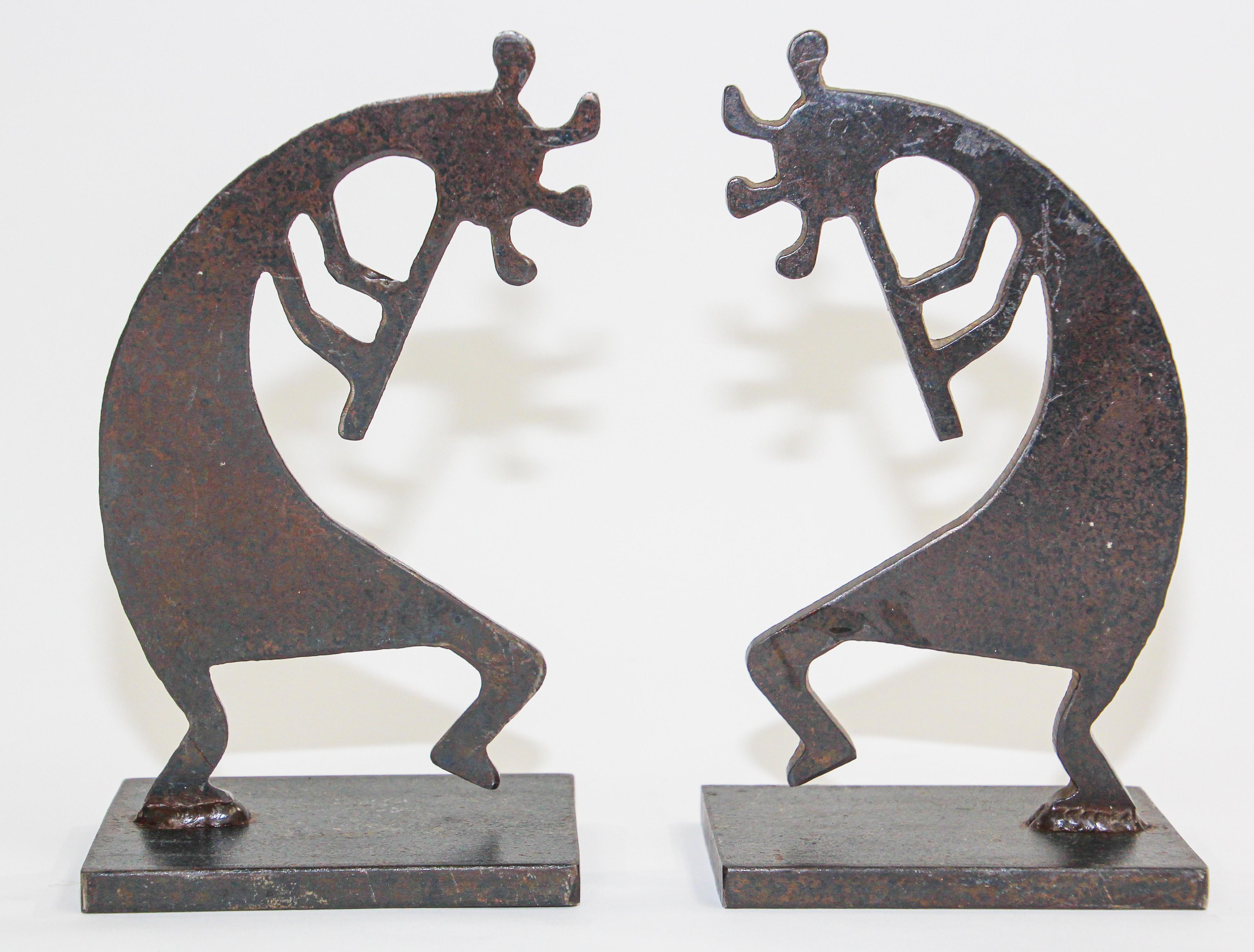 Two heavy signed Southwest Kokopelli metal sculptures. 
The sculpture features Kokopelli, a fertility deity in the shape of a humpbacked figure playing the flute. 
The sculpture and sits on a rectangular base. 
The bottom of the base is signed by