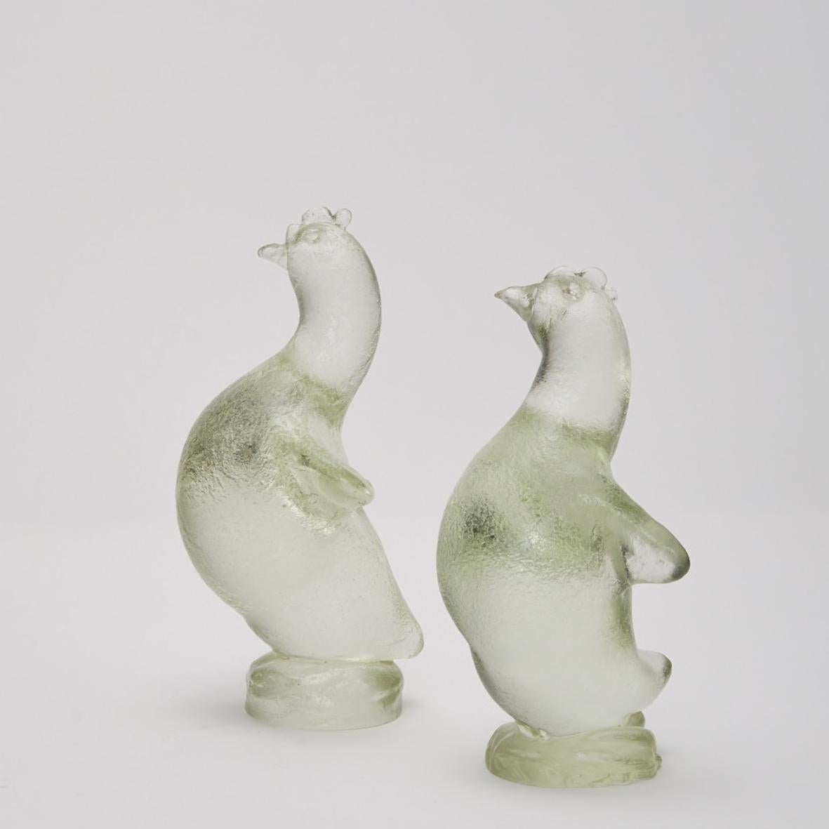 Deux poules conçues par Archimede Seguso (né en 1909 et mort en 1999), l'un des maîtres verriers vénitiens du XXe siècle. La surface des poules de verre aurait été recouverte d'une couche irrégulière de cire fondue appliquée à l'aide d'une éponge ;