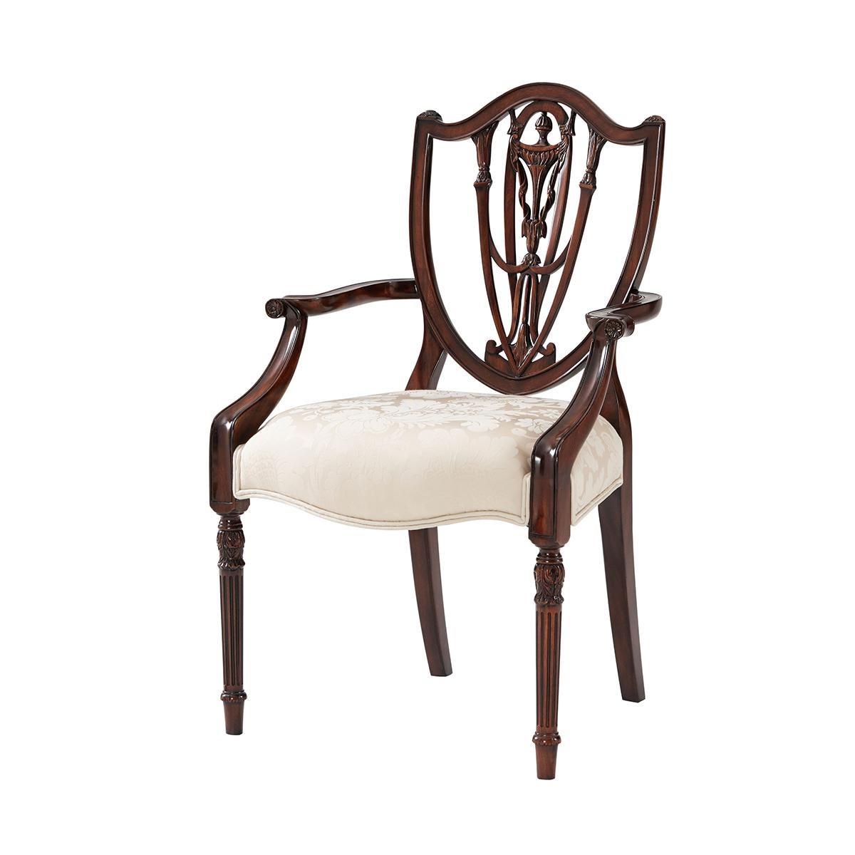 Georgian style dining chair in the manner of George Hepplewhite. With a carved shield back and vase carved splat above an upholstered seat, on carved acanthus turned and fluted tapering legs.

Dimensions: 2