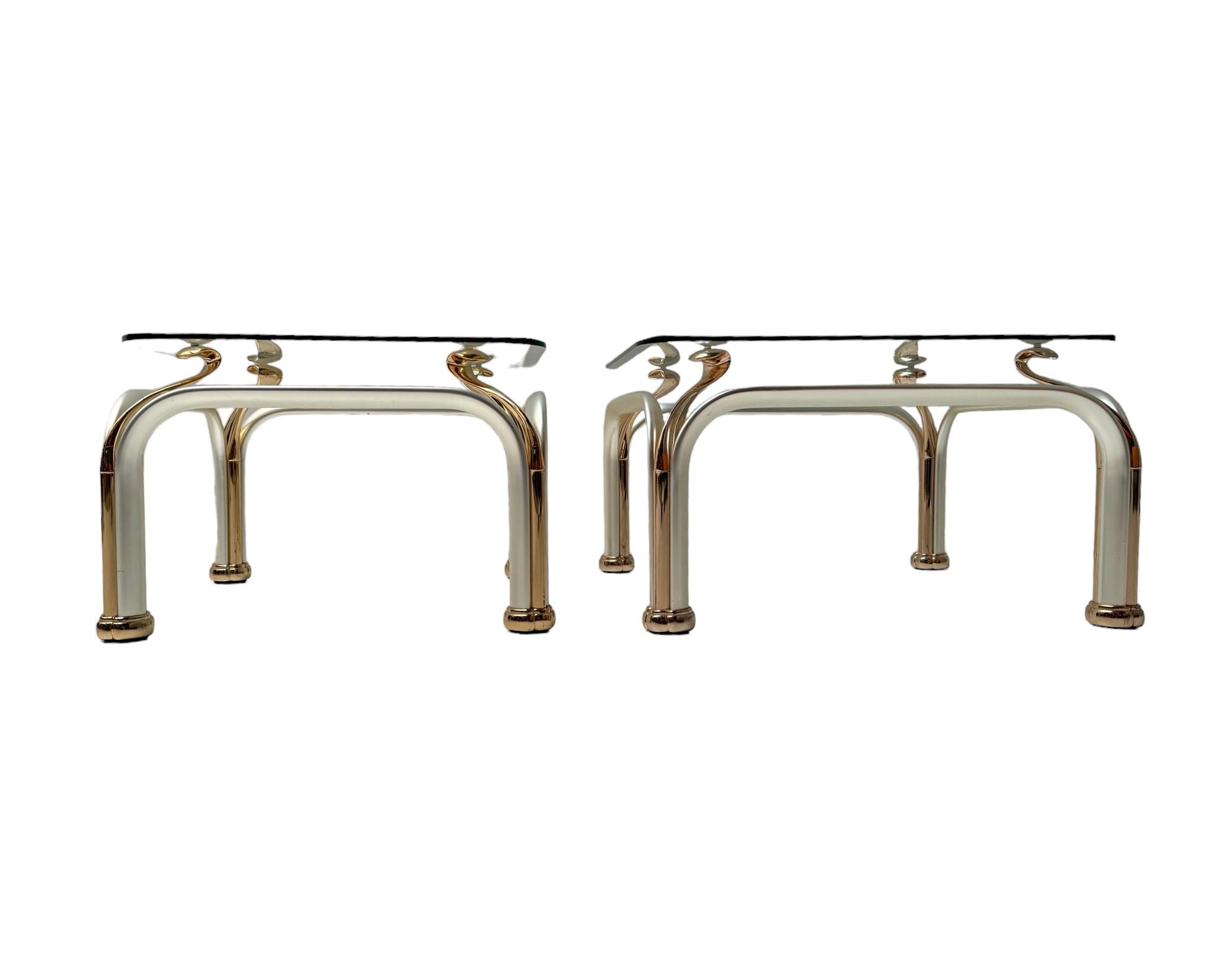 Stunning and elegant set of two Hollywood Regency side tables.
Striking Italian design from the 1980s.
Partly gilt metal abstract base with four decorative swan necks.
Two original beveled chrystal glass tops with some minor scratches,not