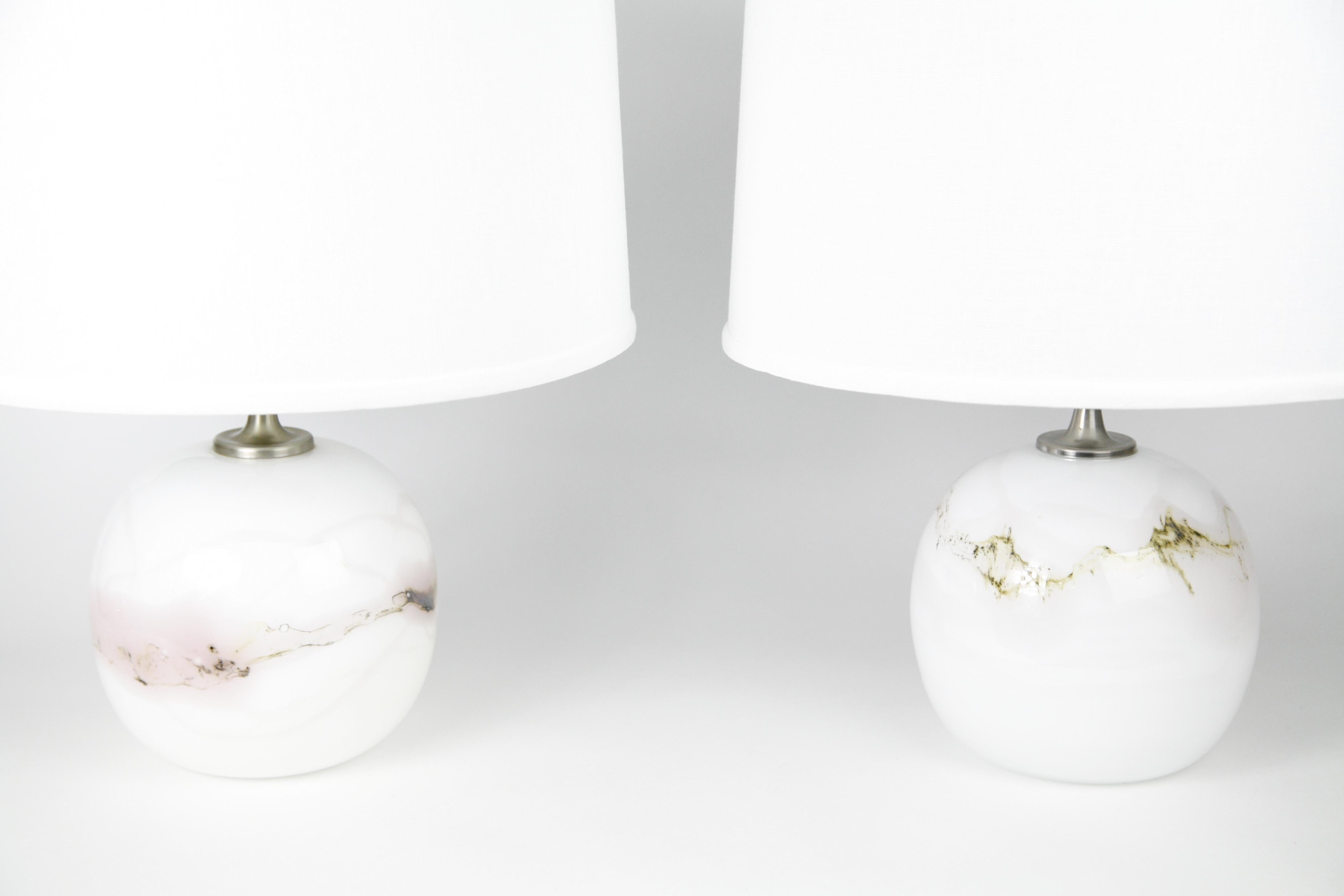 Deux lampes Holmegaard avec des accessoires en acier brossé par Holmegaard, Danemark, 1984 en blanc avec une variété de couleurs mélangées dans y compris le verre rose fondu sous-jacent le verre clair lisse conçu par Michael Bang, 1984.
La hauteur