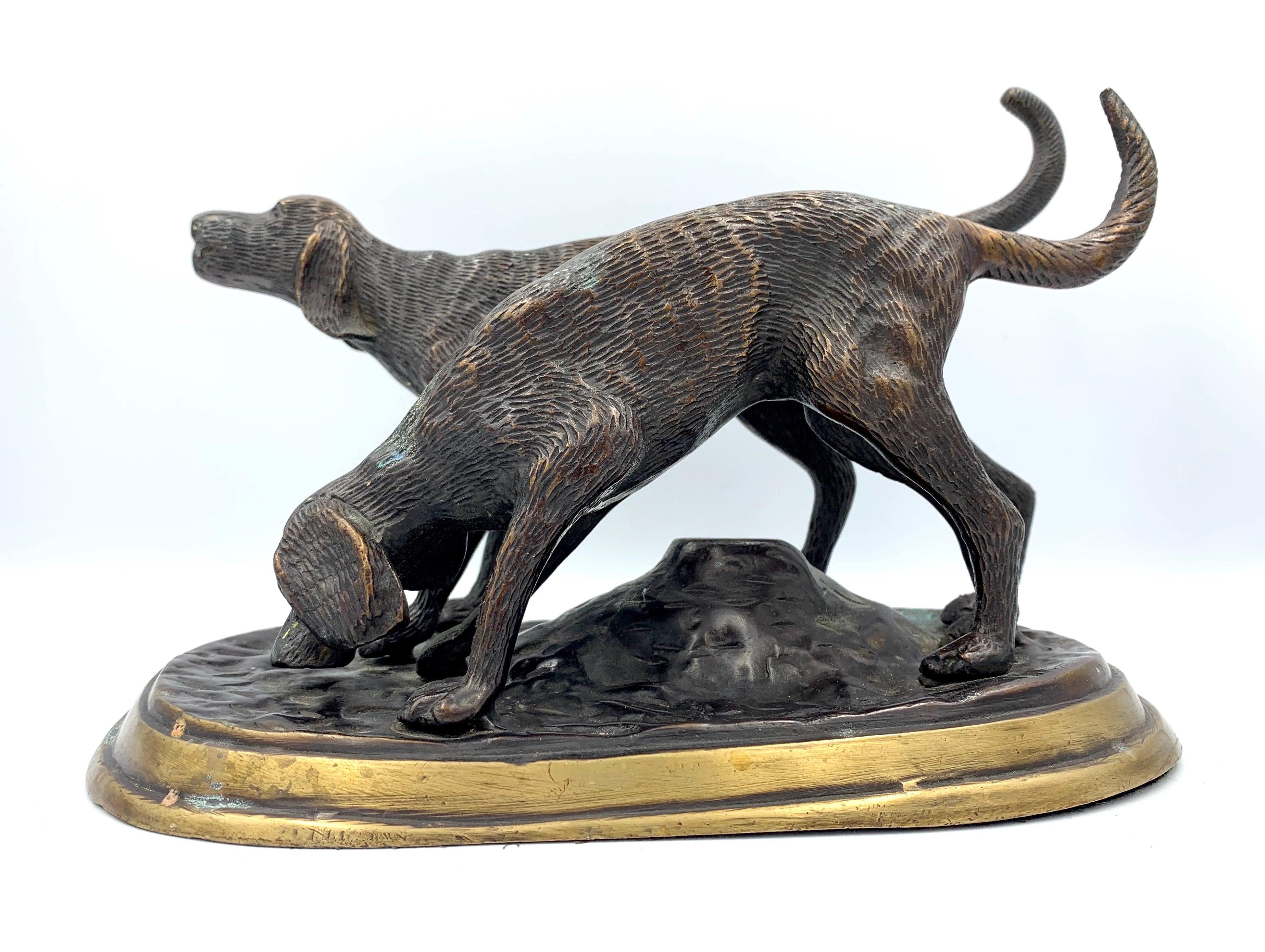 Presented is a bronze sculpture of two hunting dogs. One dog is depicted with his nose to the ground, having caught the scent of the hunt. The other dog points ahead, his body positioned to start the chase. The sculpture was cast using the lost wax